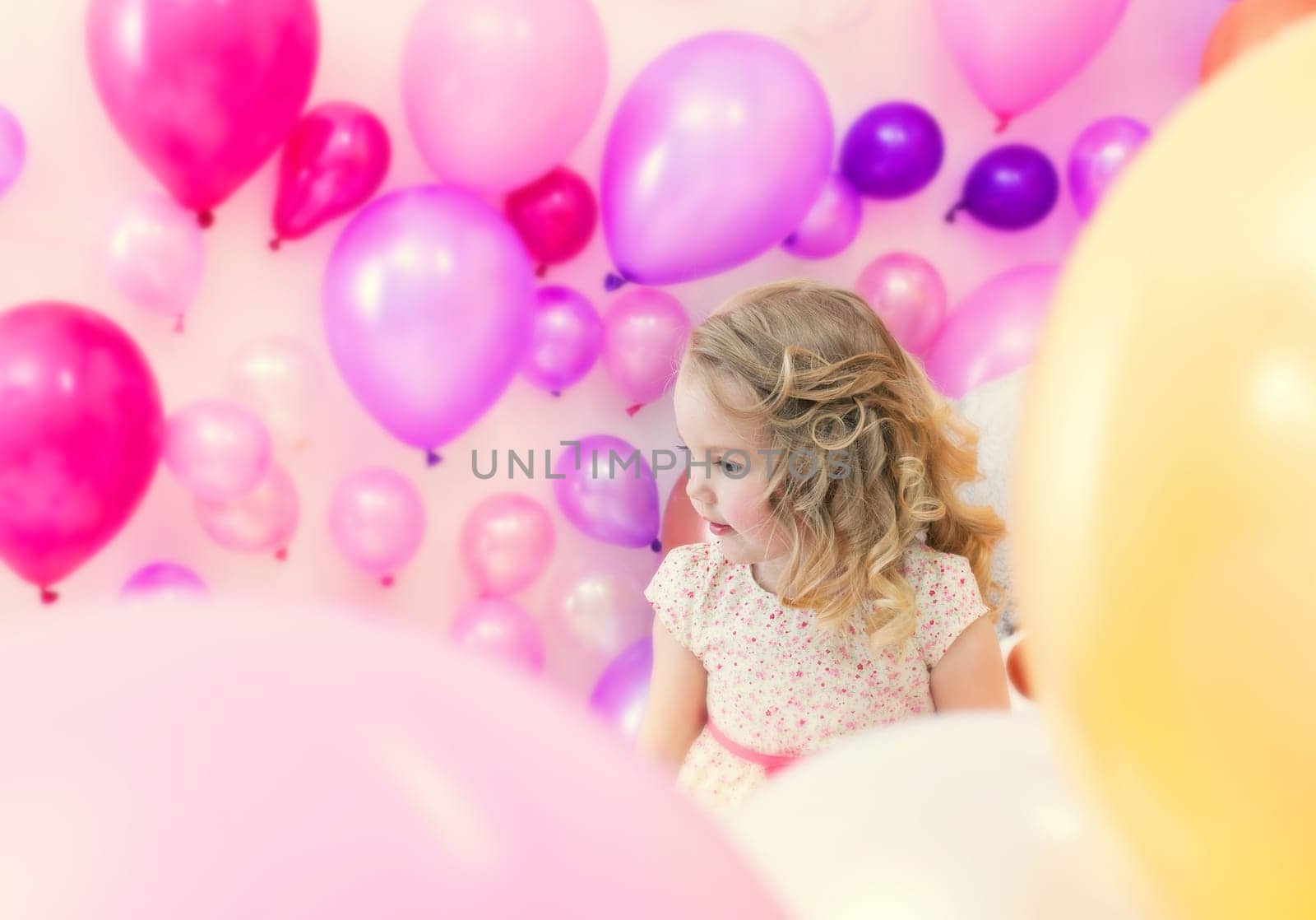 Pretty girl posing in studio where lot of pink balloons