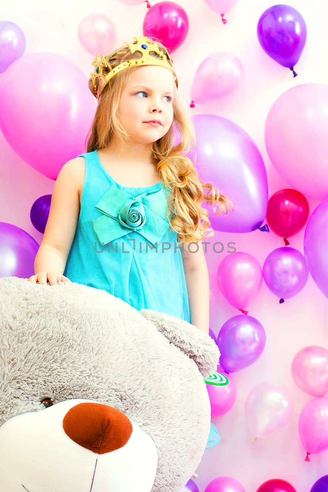Studio shot of cute little girl posing with teddy bear