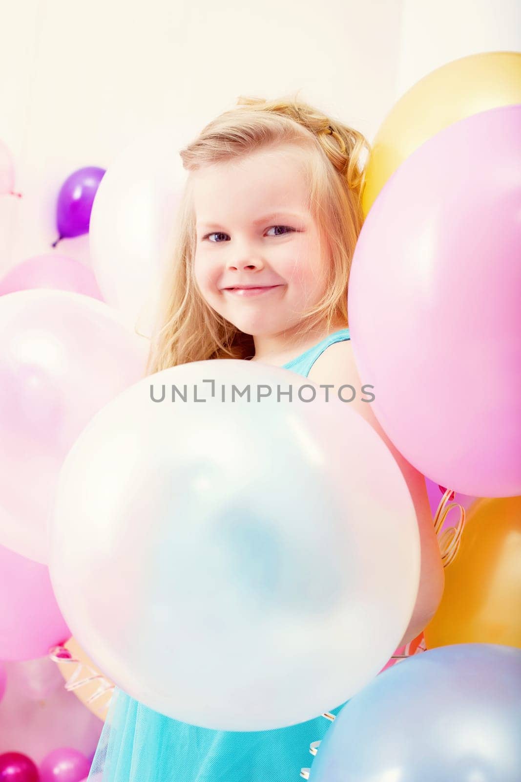 Funny little girl posing with balloons, close-up