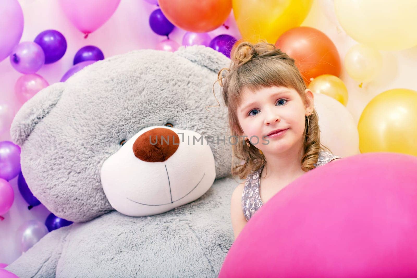 Portrait of lovely blue-eyed girl with big teddy bear