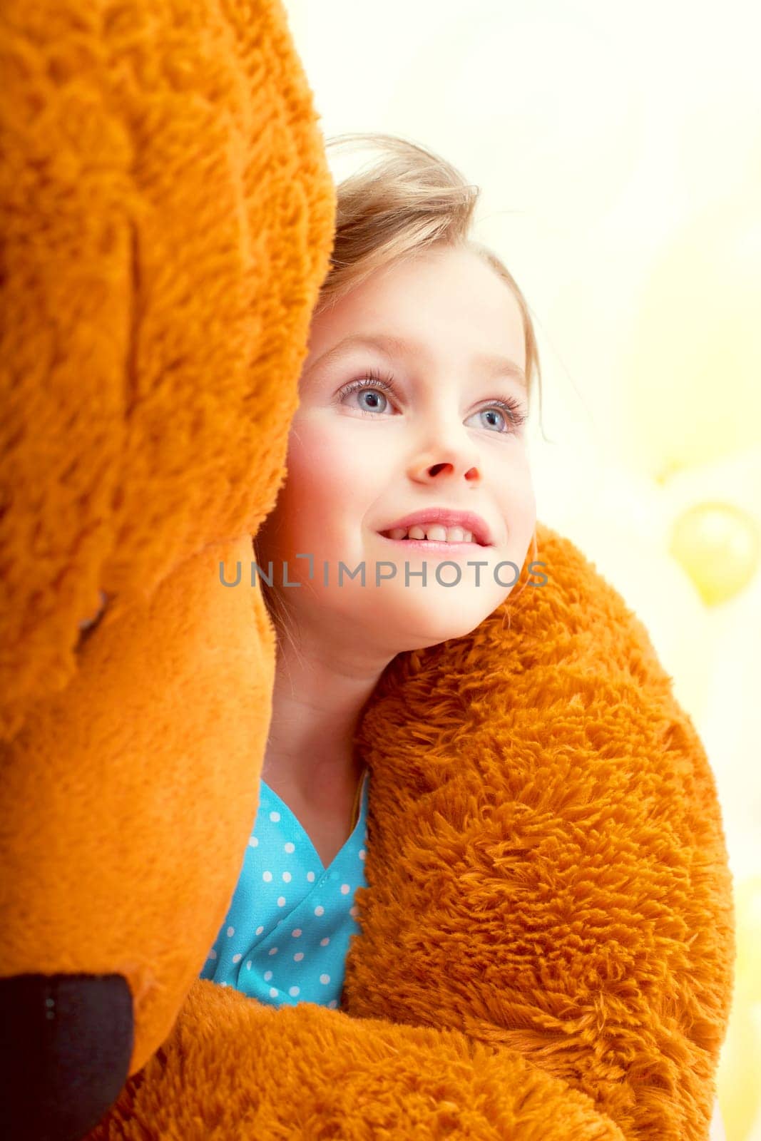 Portrait of cute little girl in arms of teddy bear