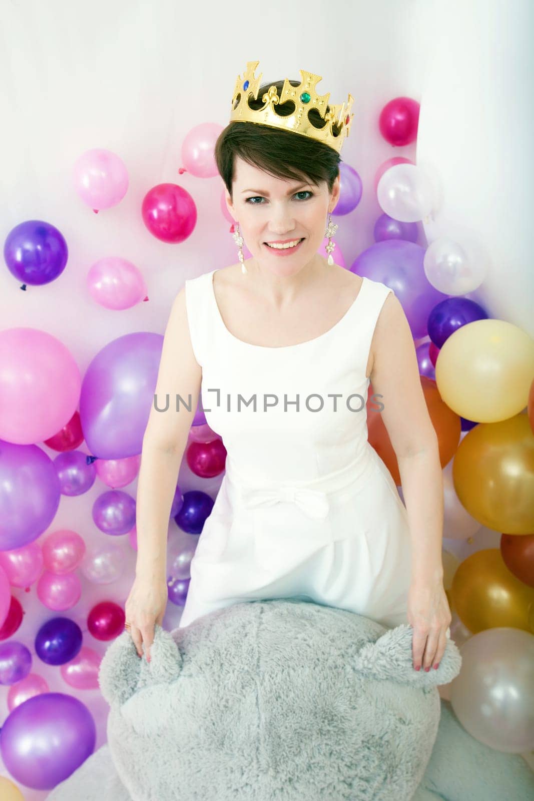 Smiling middle-aged woman posing with big teddy bear