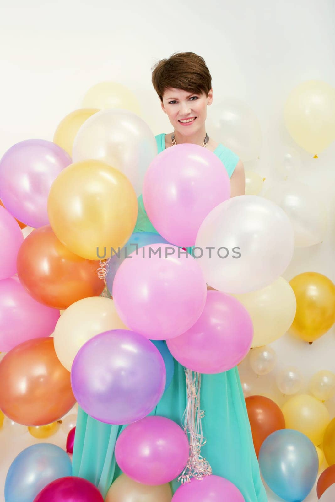 Beautiful woman holds big bunch of colorful balloons