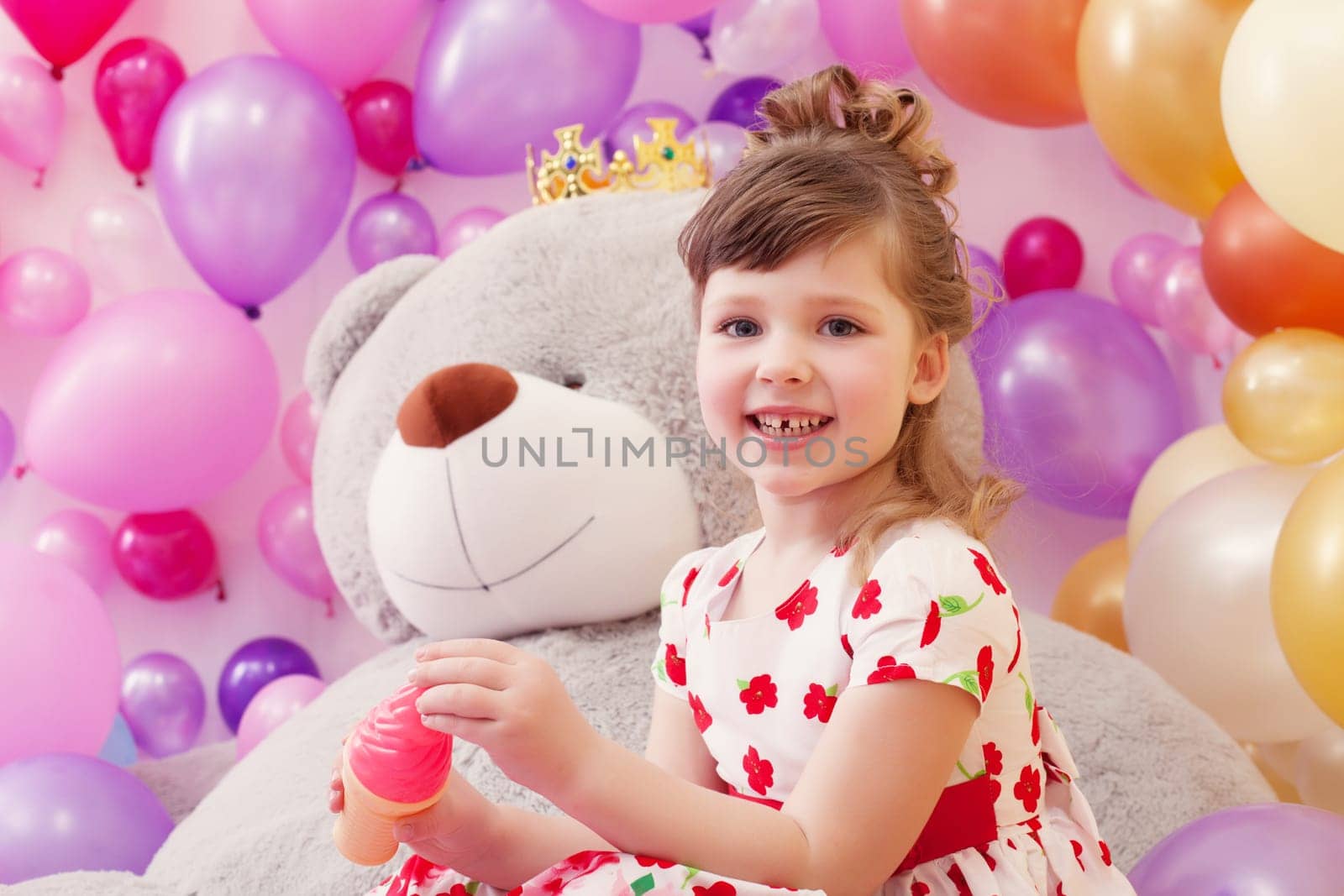 Studio shot of joyful little girl posing in playroom