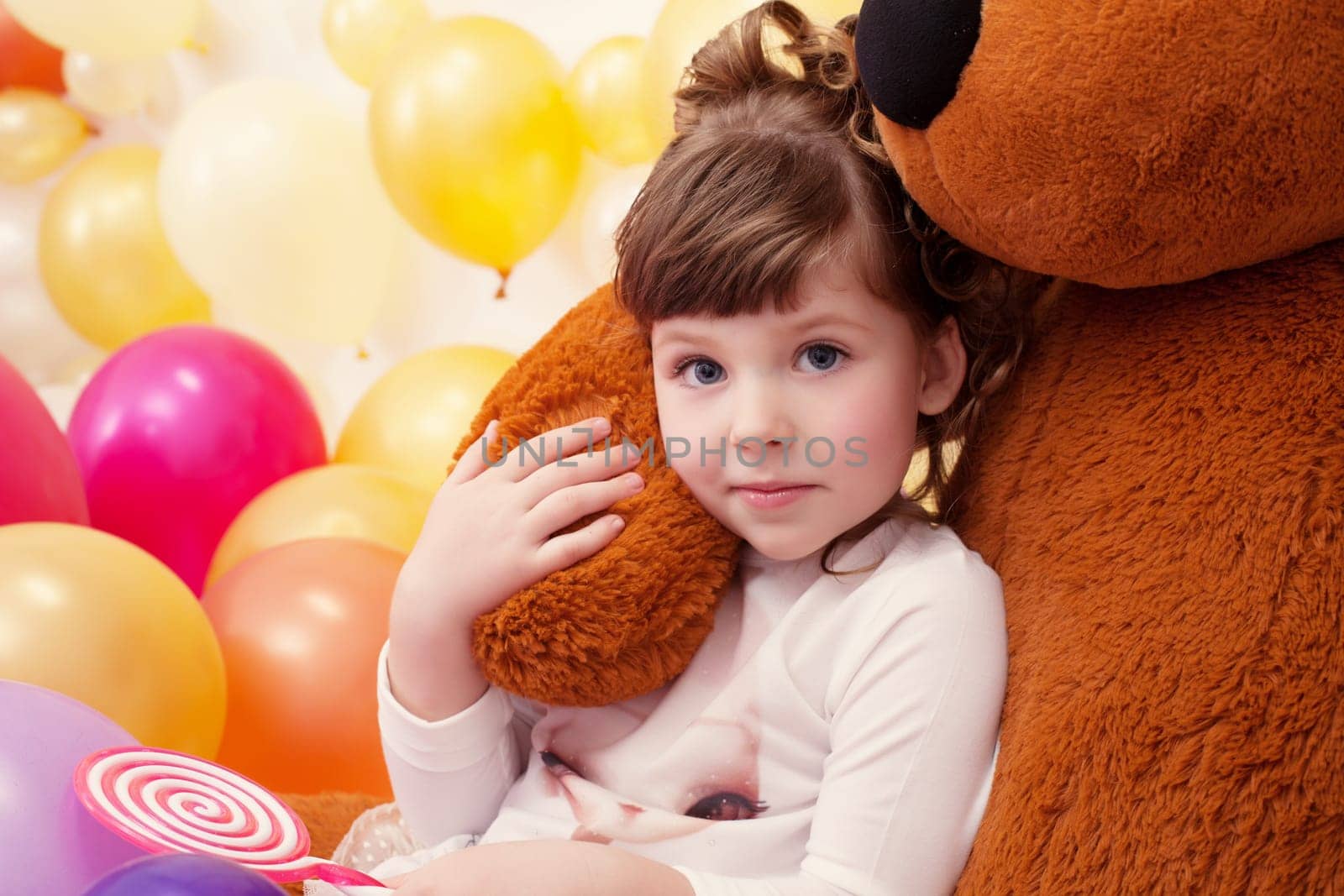 Portrait of lovely little girl hugging teddy bear, close-up