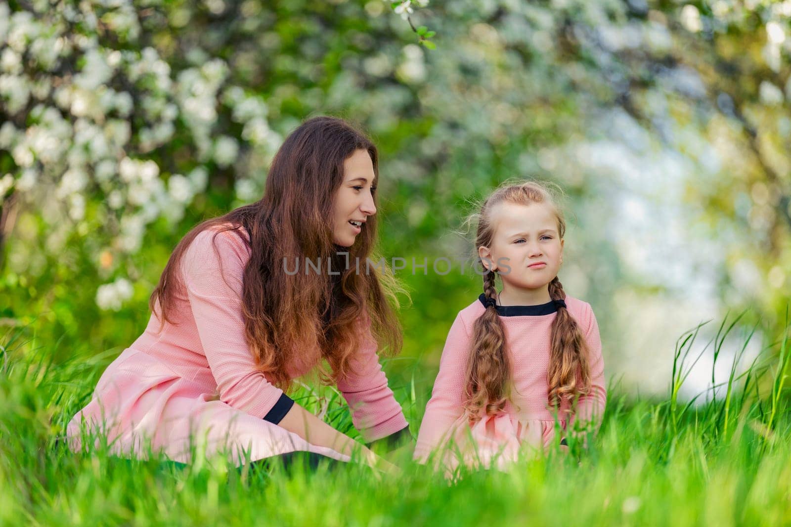 mother and daughter sitting outdoors by zokov