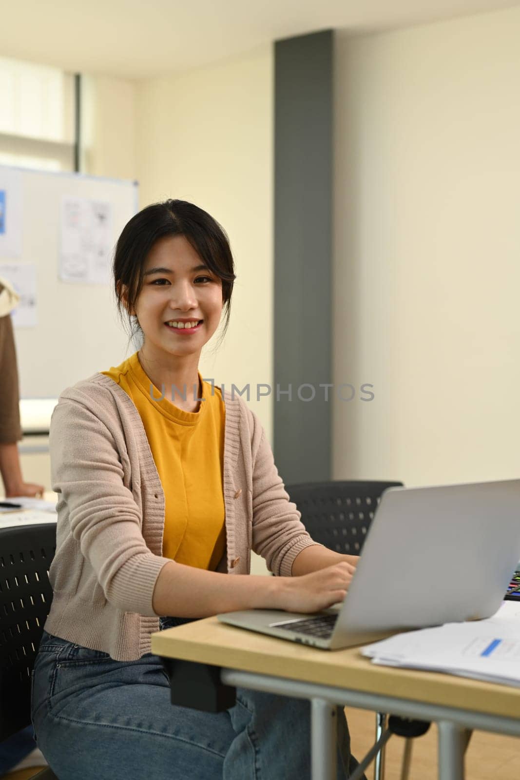 Portrait of pretty young asian woman developer woman working on app design and user interface at workstation.
