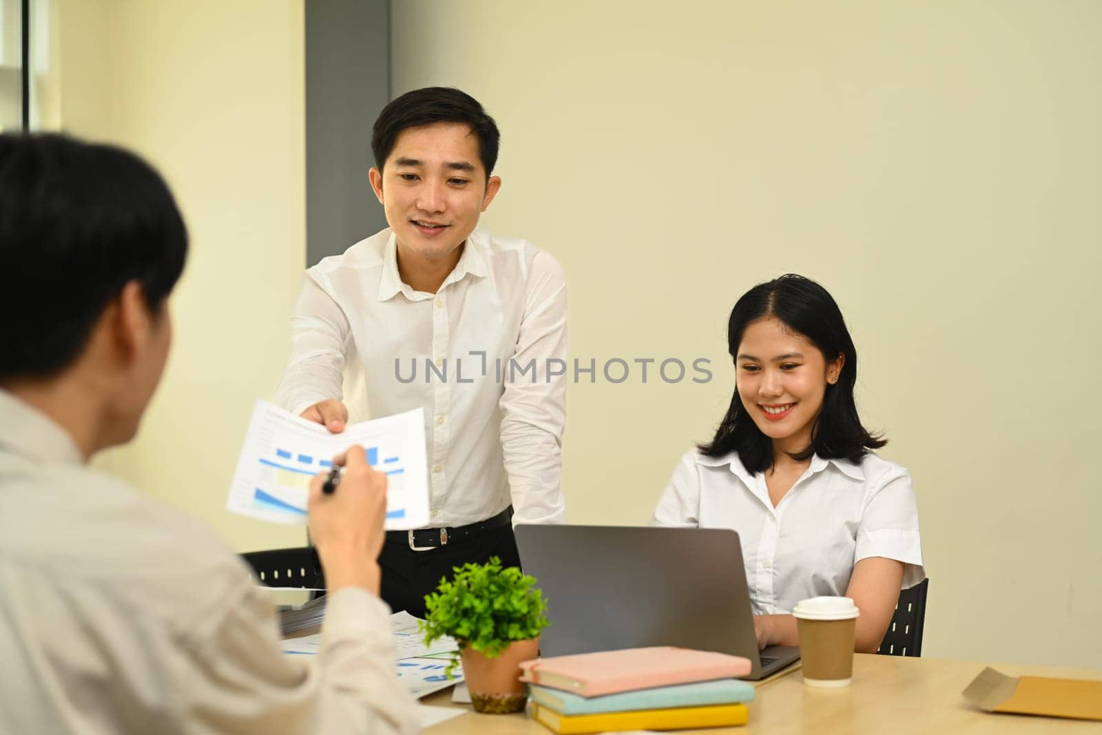 Accountant team comparing corporate income for previous year with current one at office by prathanchorruangsak