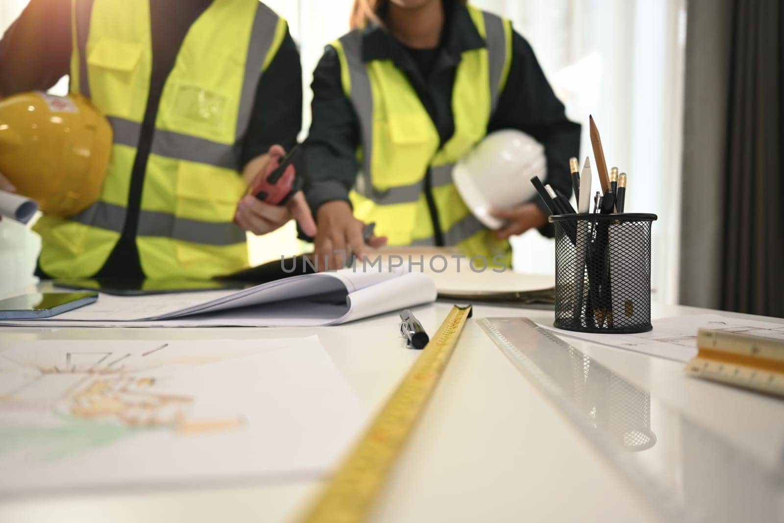 Architect team brainstorming, planning development details at construction office.