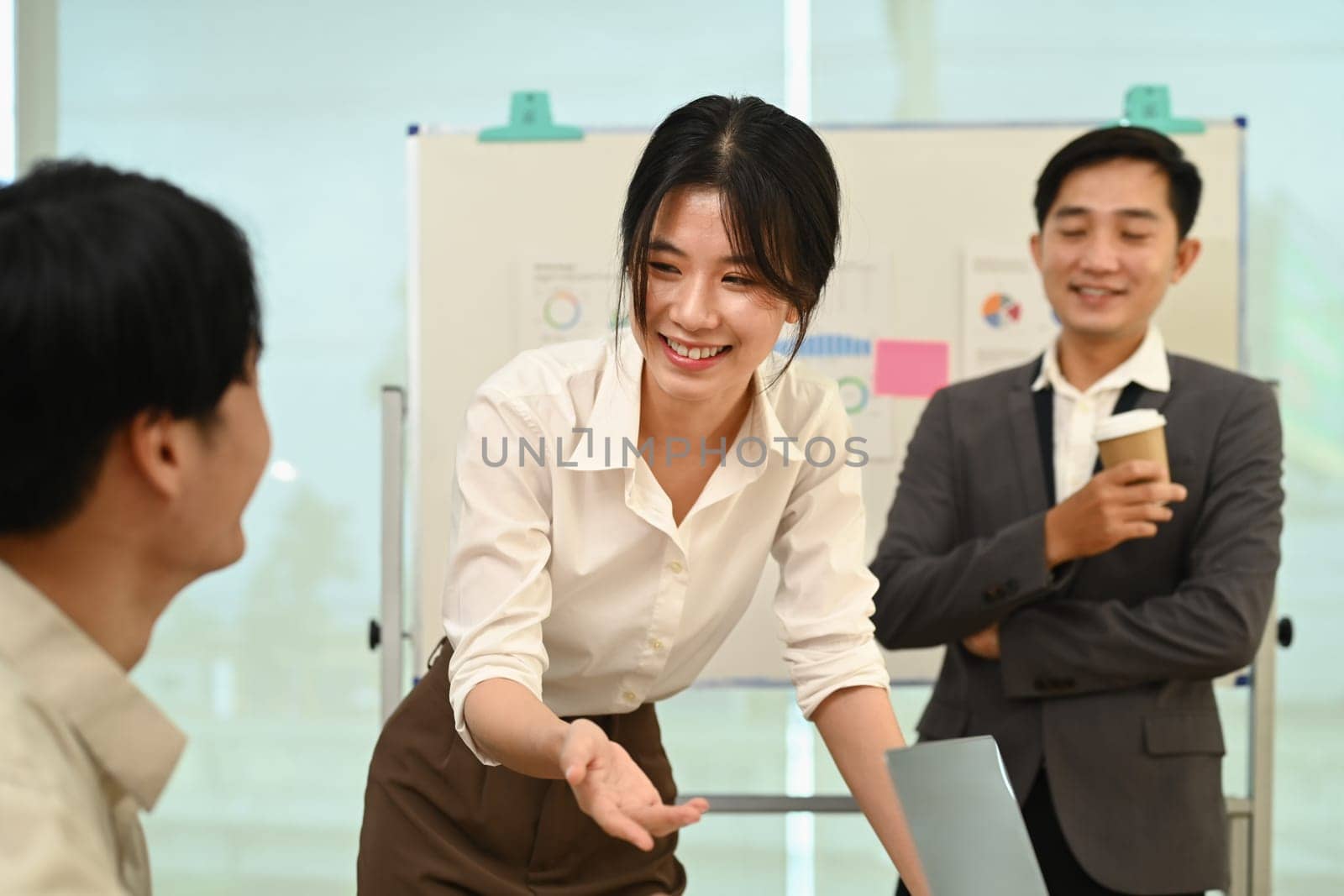 Attractive asian businesswoman working on new business strategy with colleagues at modern office by prathanchorruangsak