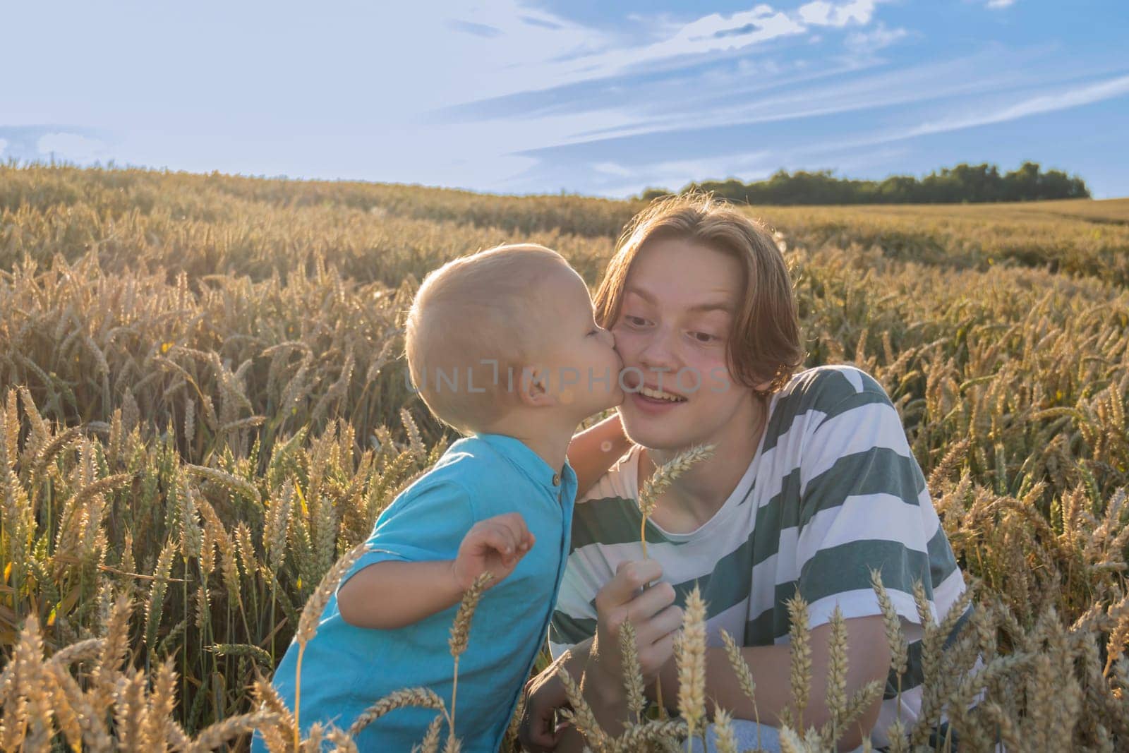 A little boy and his teenage brother are having fun walking in a field with ripe wheat. Grain for making bread. the concept of economic crisis and hunger