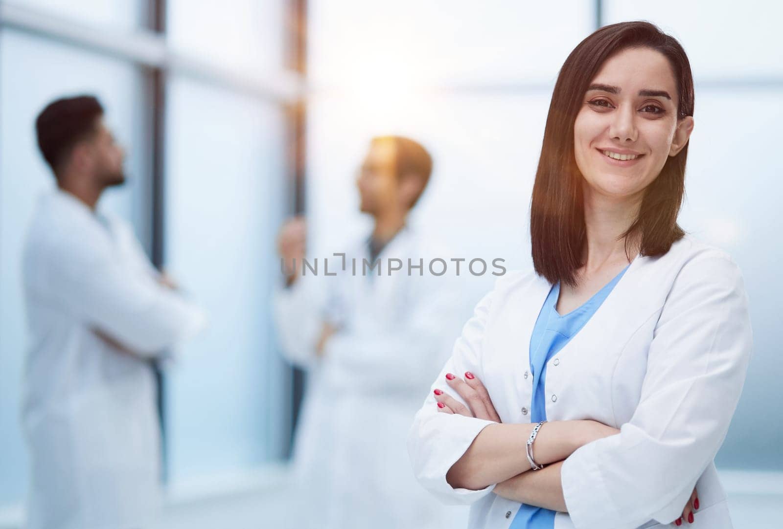 Confident female doctor posing in her office and smiling at camera, health care and prevention concept