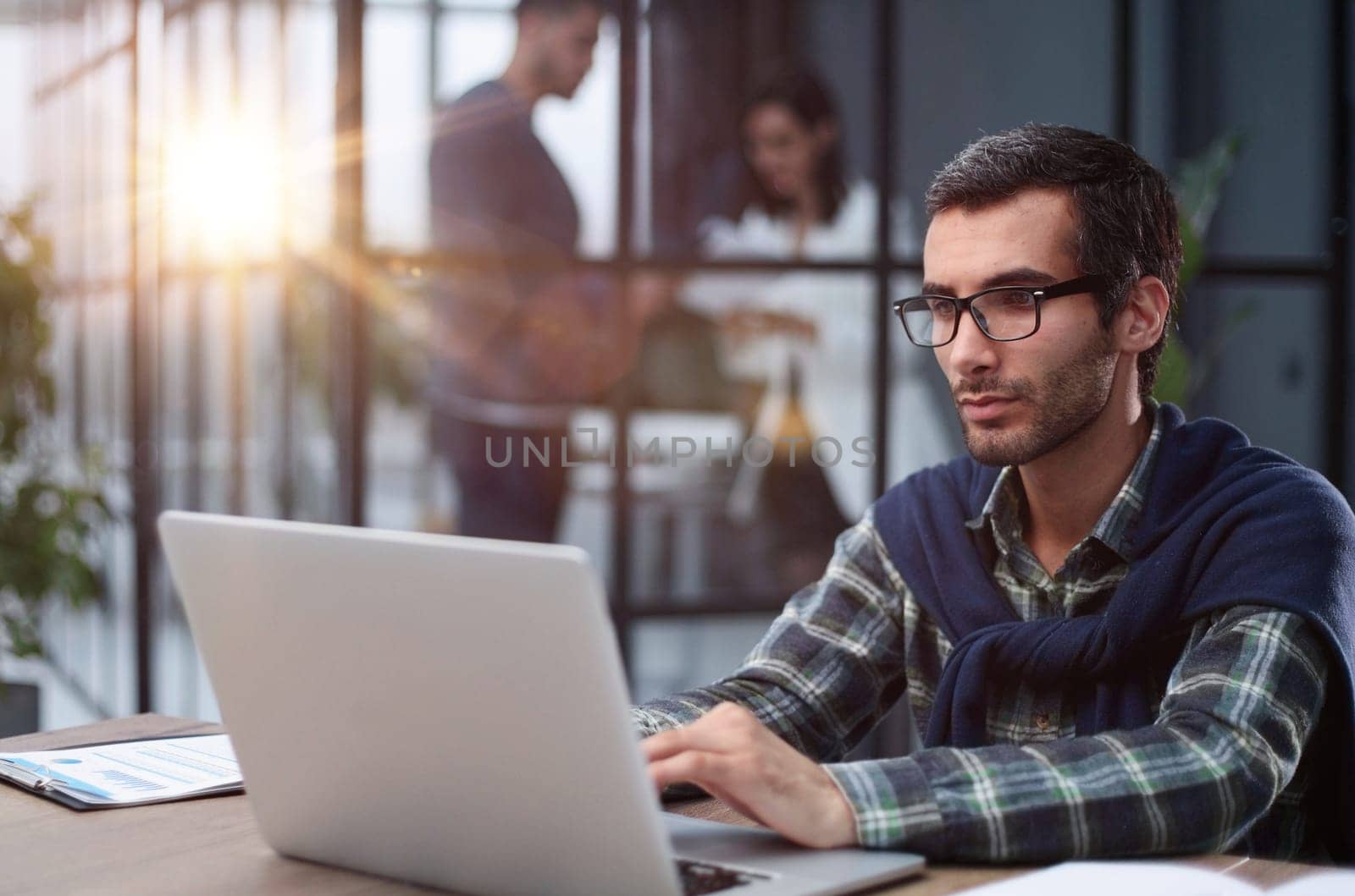 business man in glasses and casual clothes working on laptop in modern office