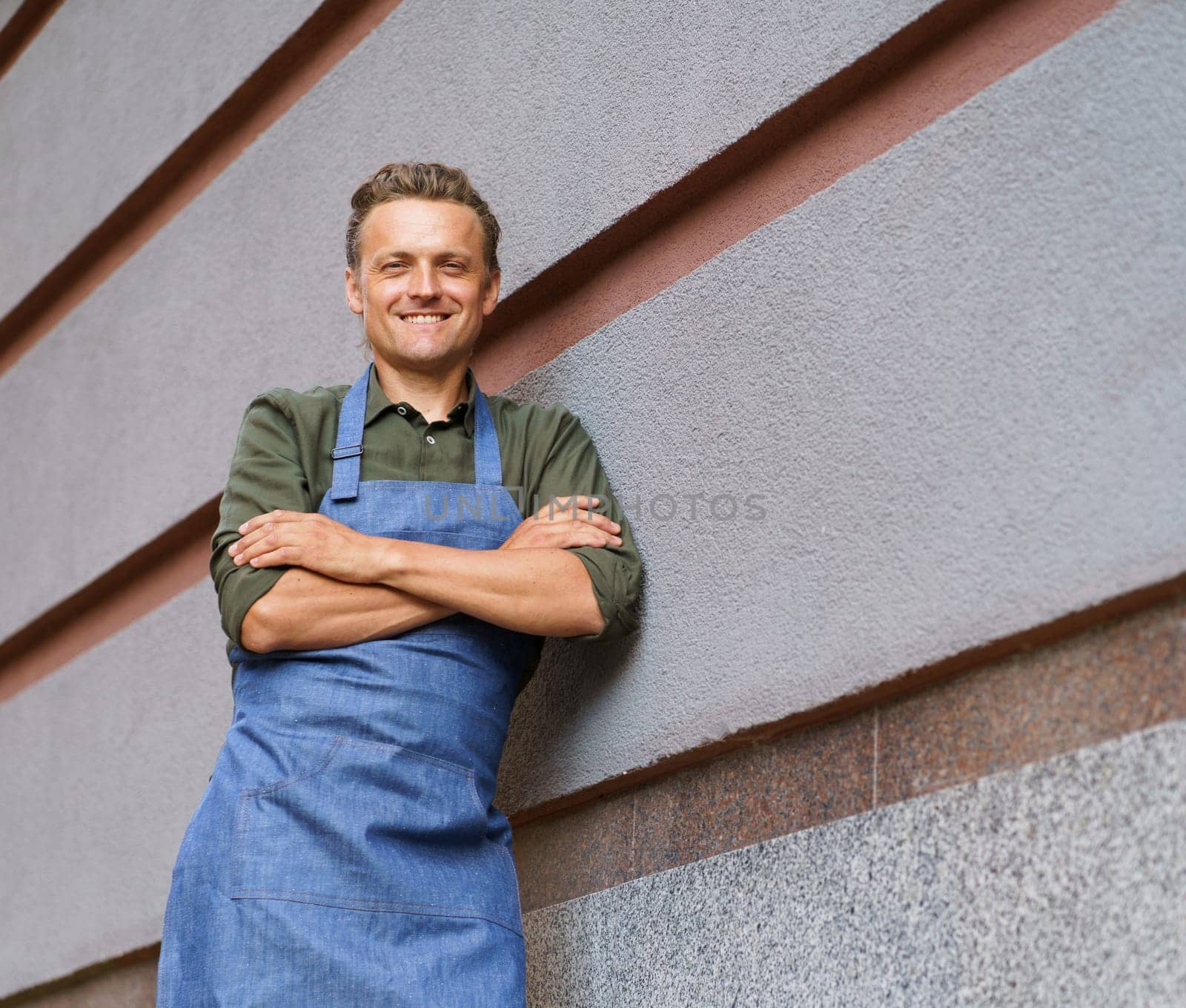 Waiter or service man positioned against a restaurant wall. With a professional demeanor, the individual exudes confidence and embodies the core values of hospitality and customer service. . High quality photo