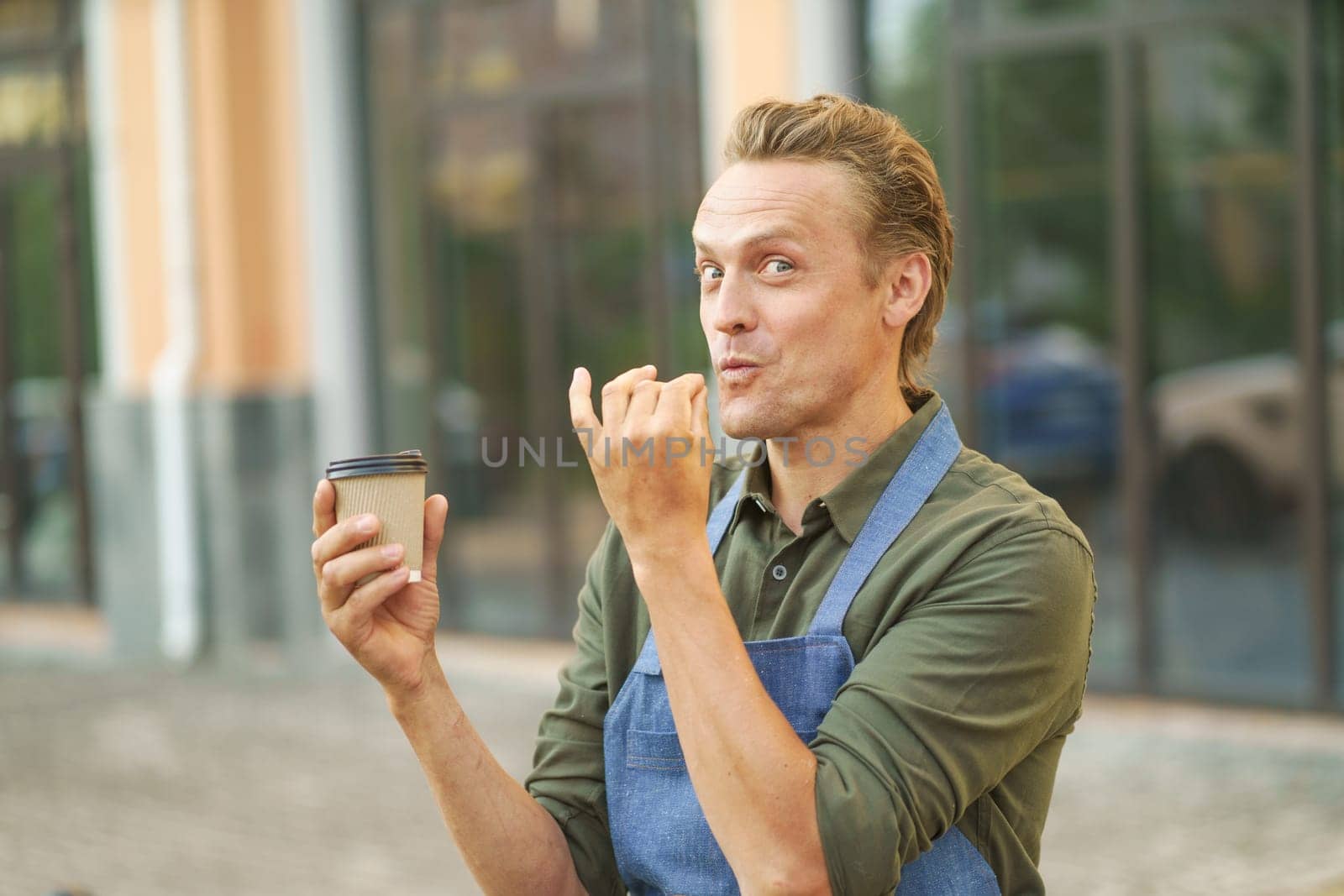 Waiter presenting delicious and tasty cup of coffee in paper cup to-go. With smile on face, waiter highlights tempting aroma and flavor of coffee, enticing viewer to indulge in delightful beverage. High quality photo
