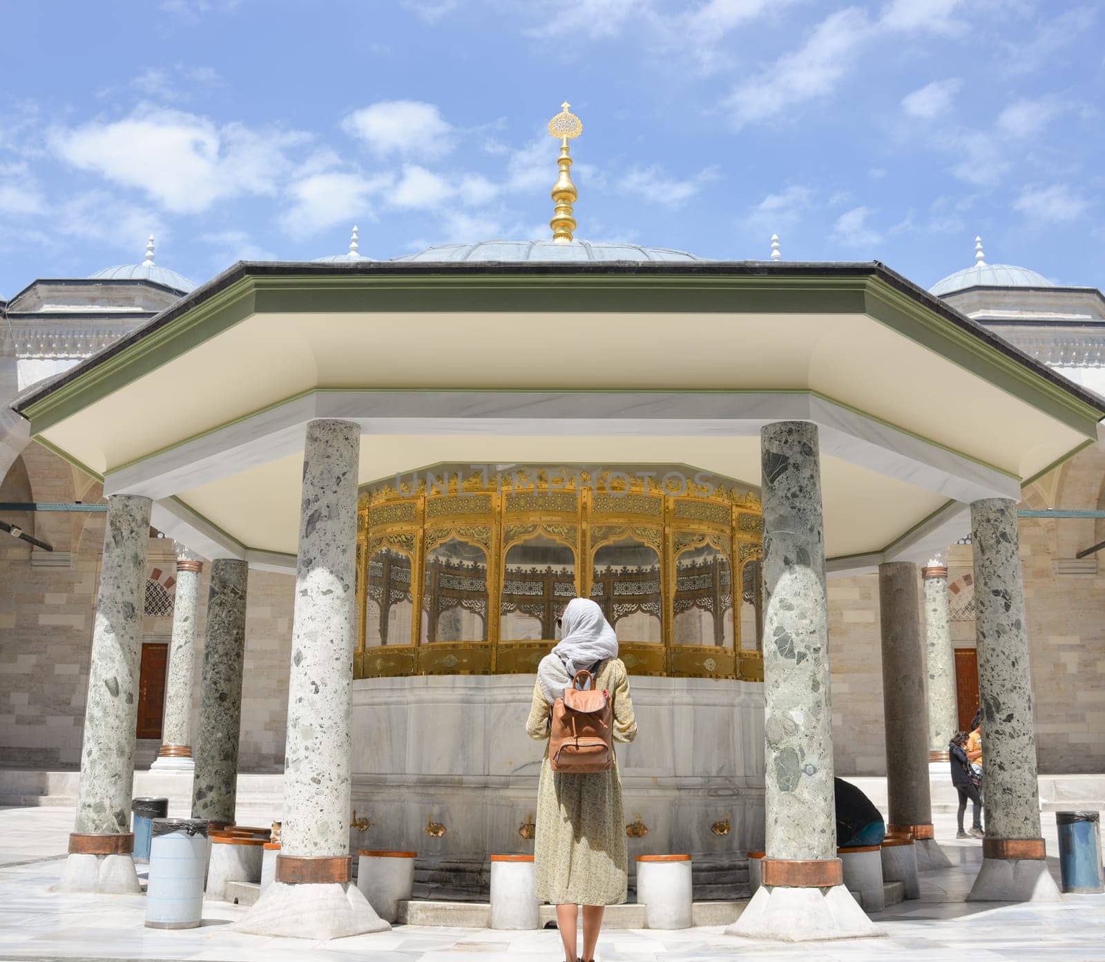 Happy attractive muslim woman near mosque in istanbul turkey posing in courtyard of mosque, religion and travel concept