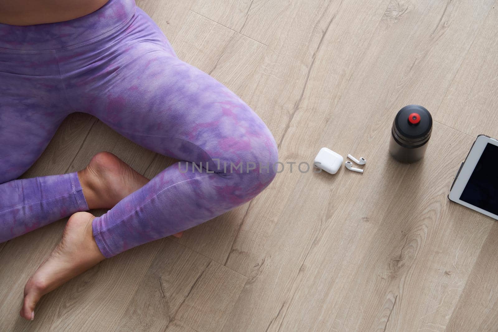 Top view of beautiful young woman in sports clothing meditating while sitting in lotus position