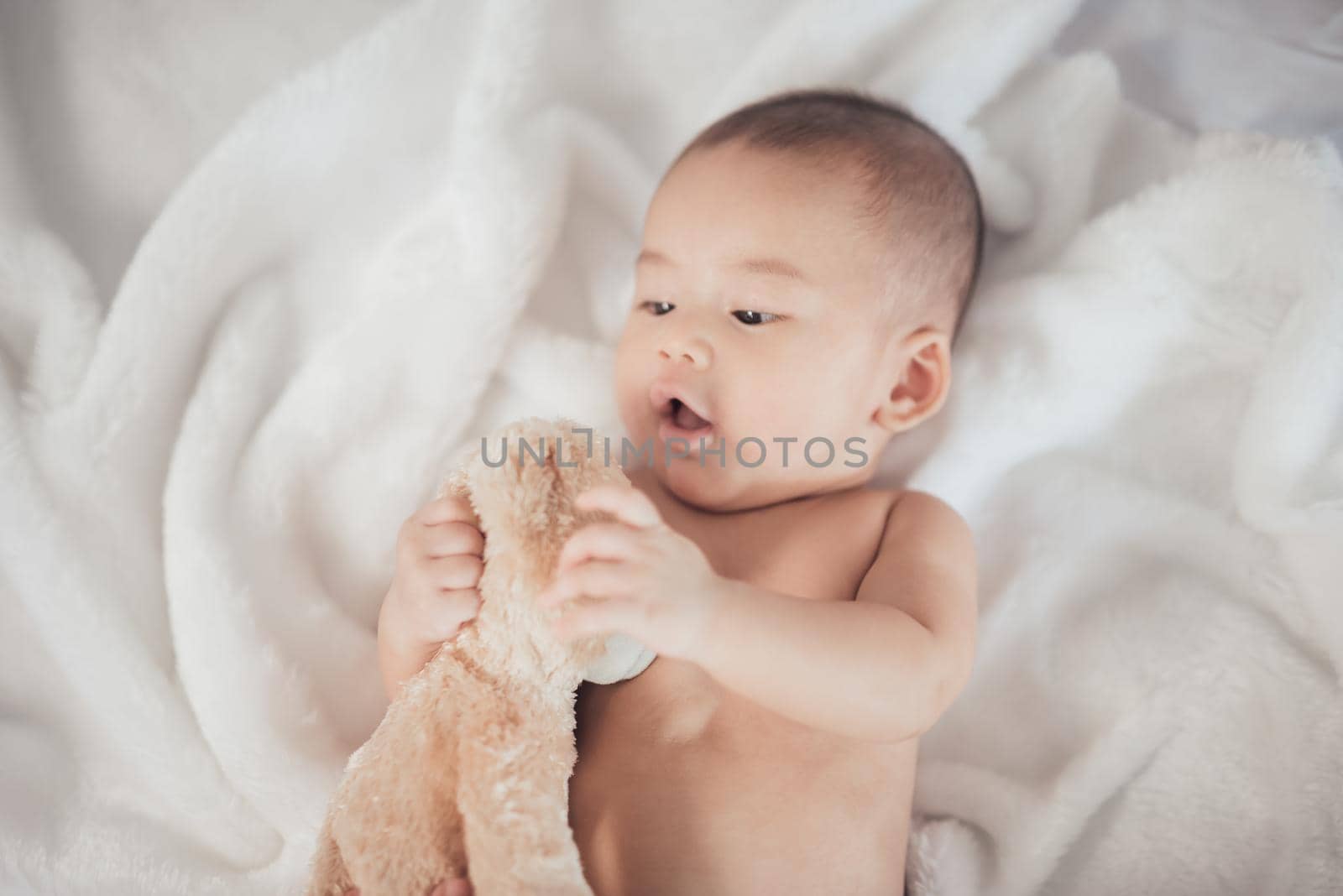 portrait asia baby on white bed by Wmpix