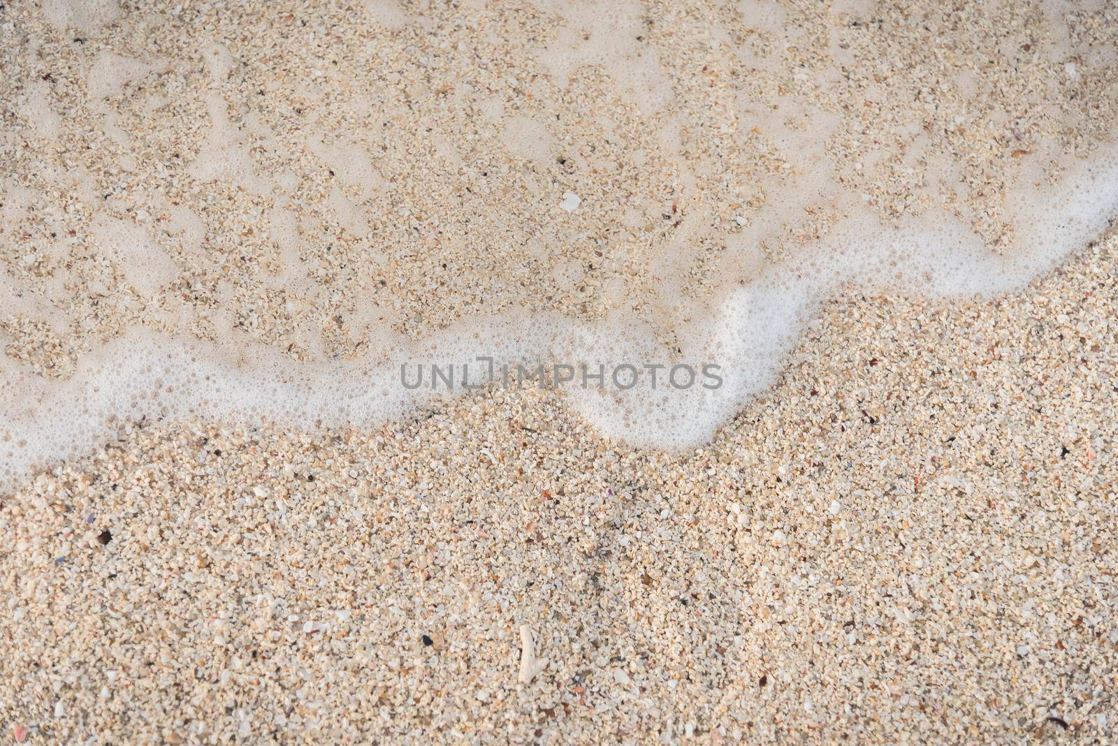 Soft wave of the sea on the sandy beach by Wmpix