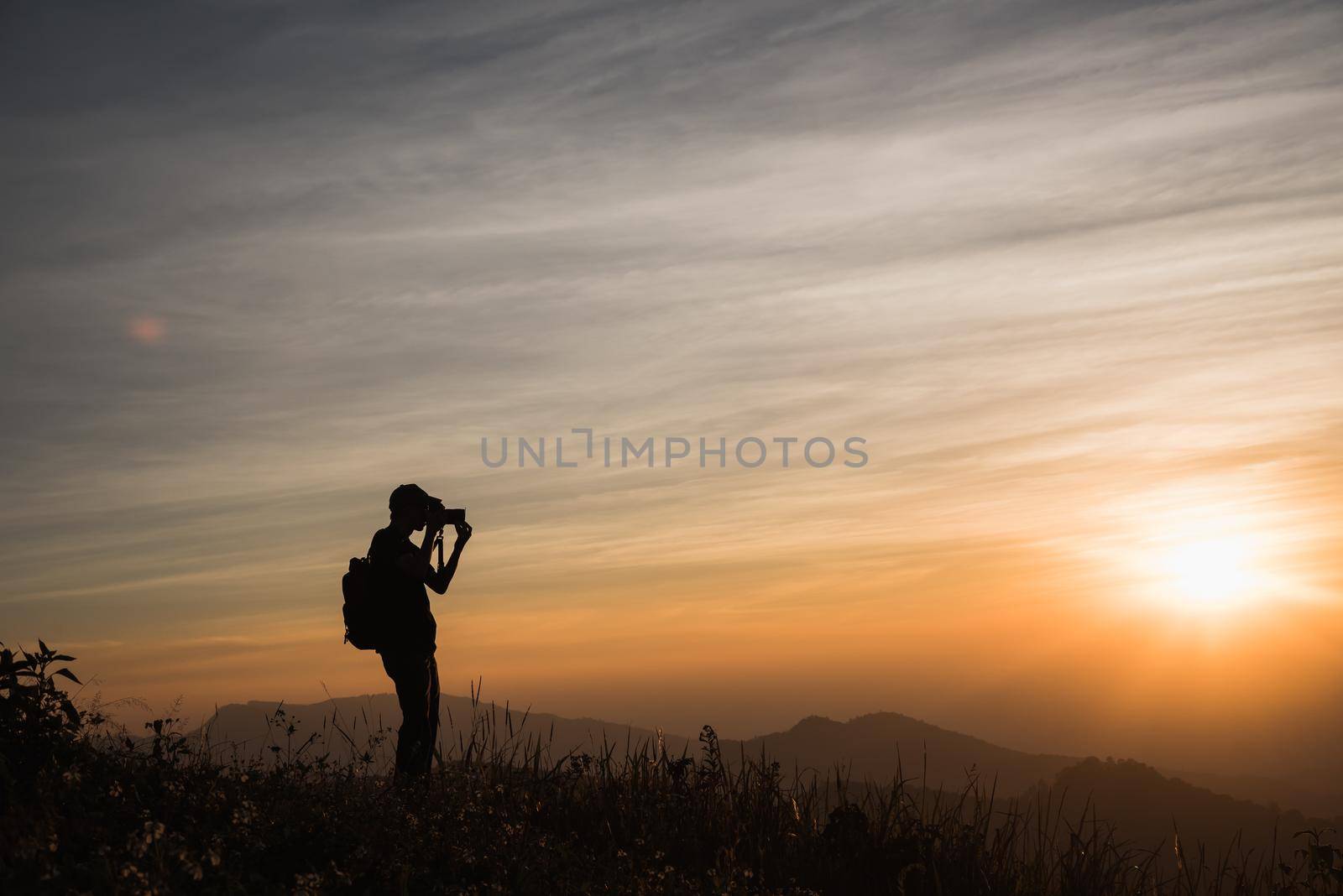 Photographer Silhouettes On Cliff Against Colorful Twilight Sky by Wmpix
