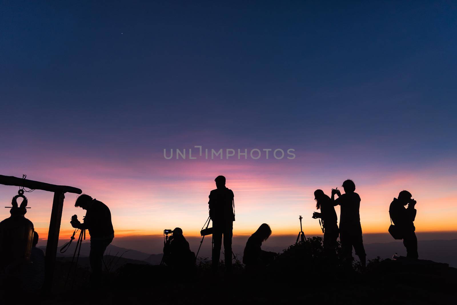 Photographers Silhouettes On Cliff Against Colorful Twilight Sky