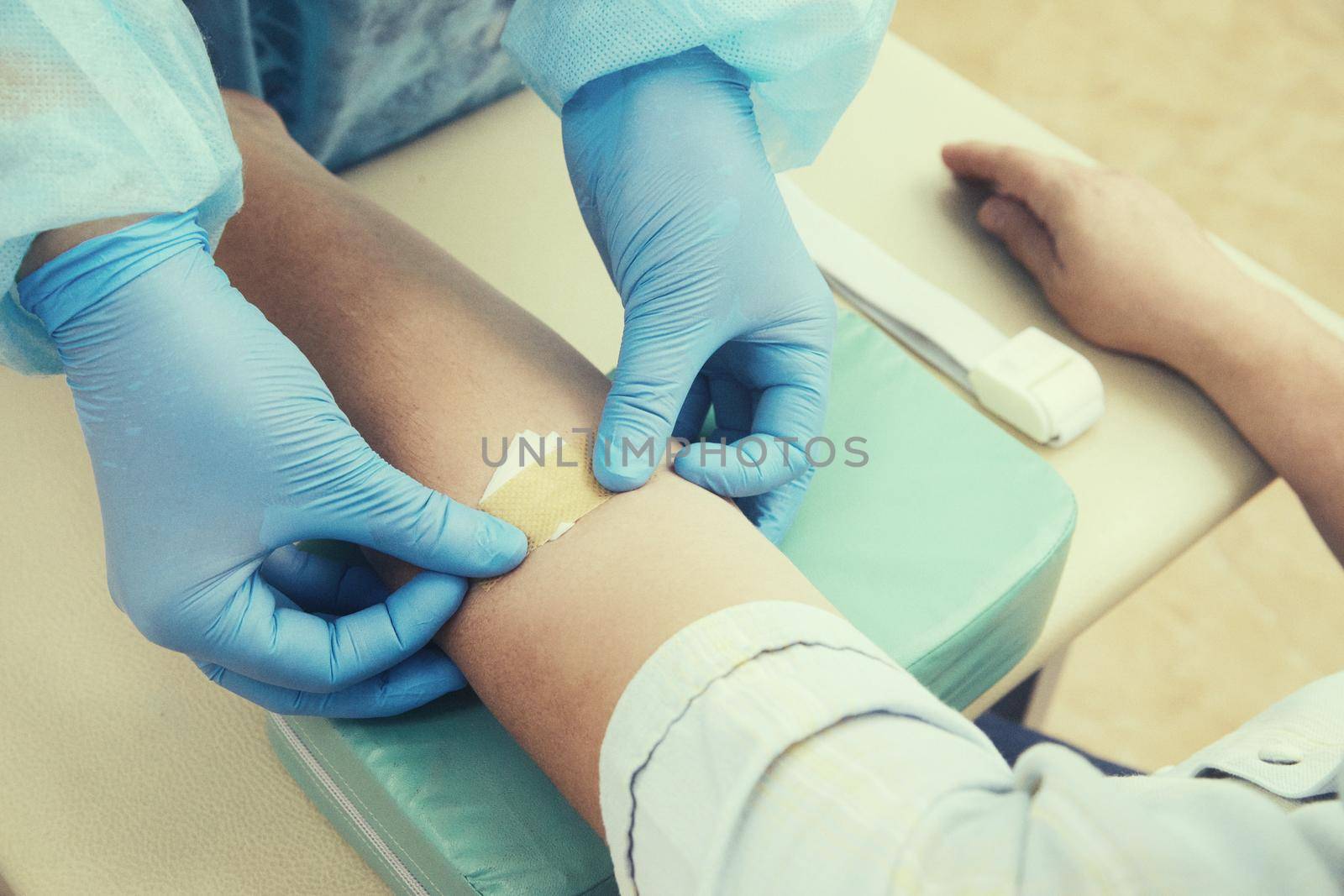 Nurse doing blood test from vein. Covid testing concept. green tonning. Using medical tape