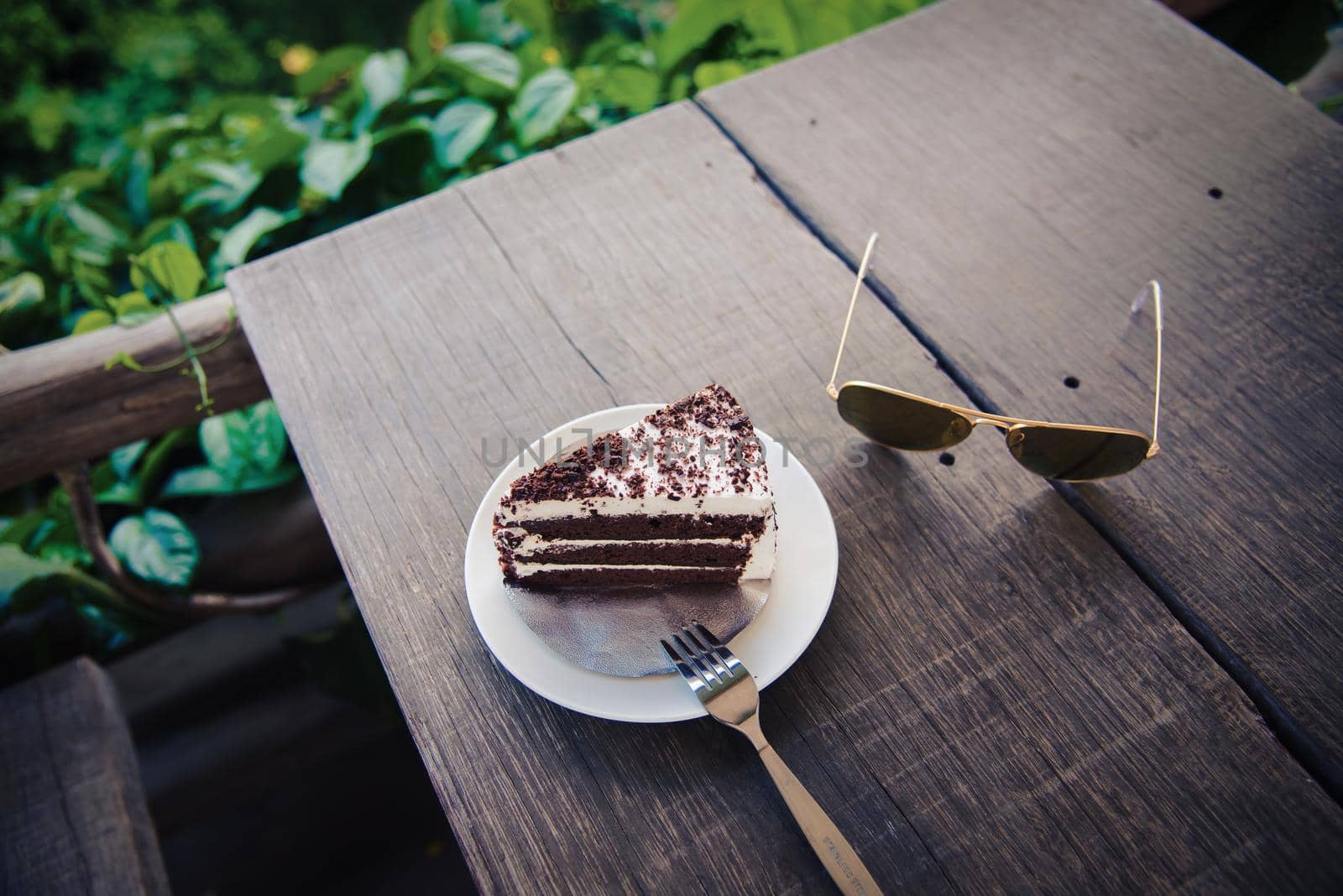 Delicious chocolate cake with glasses on table by Wmpix