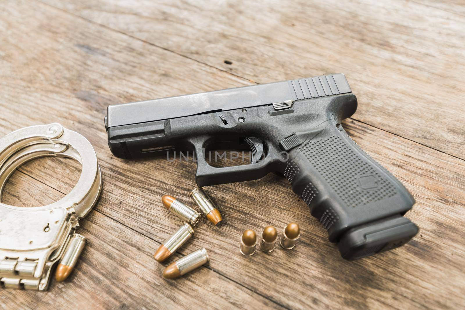 handgun bullets on wood table by Wmpix