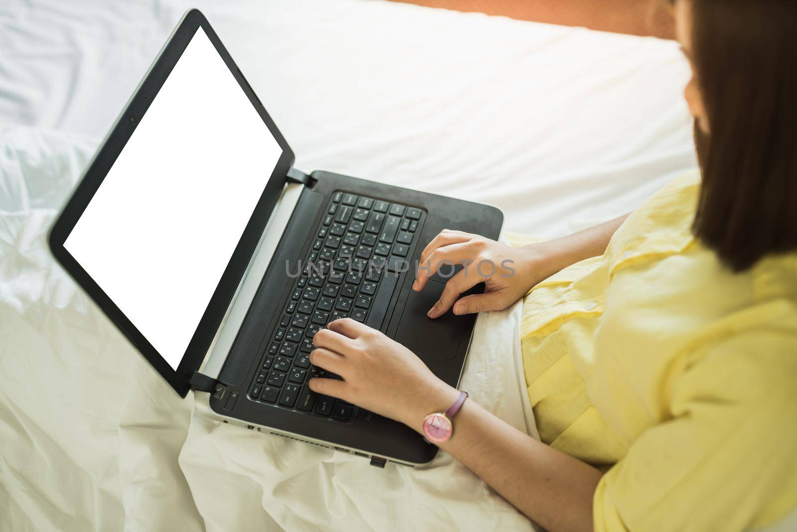 young woman using laptop in bedroom at home
