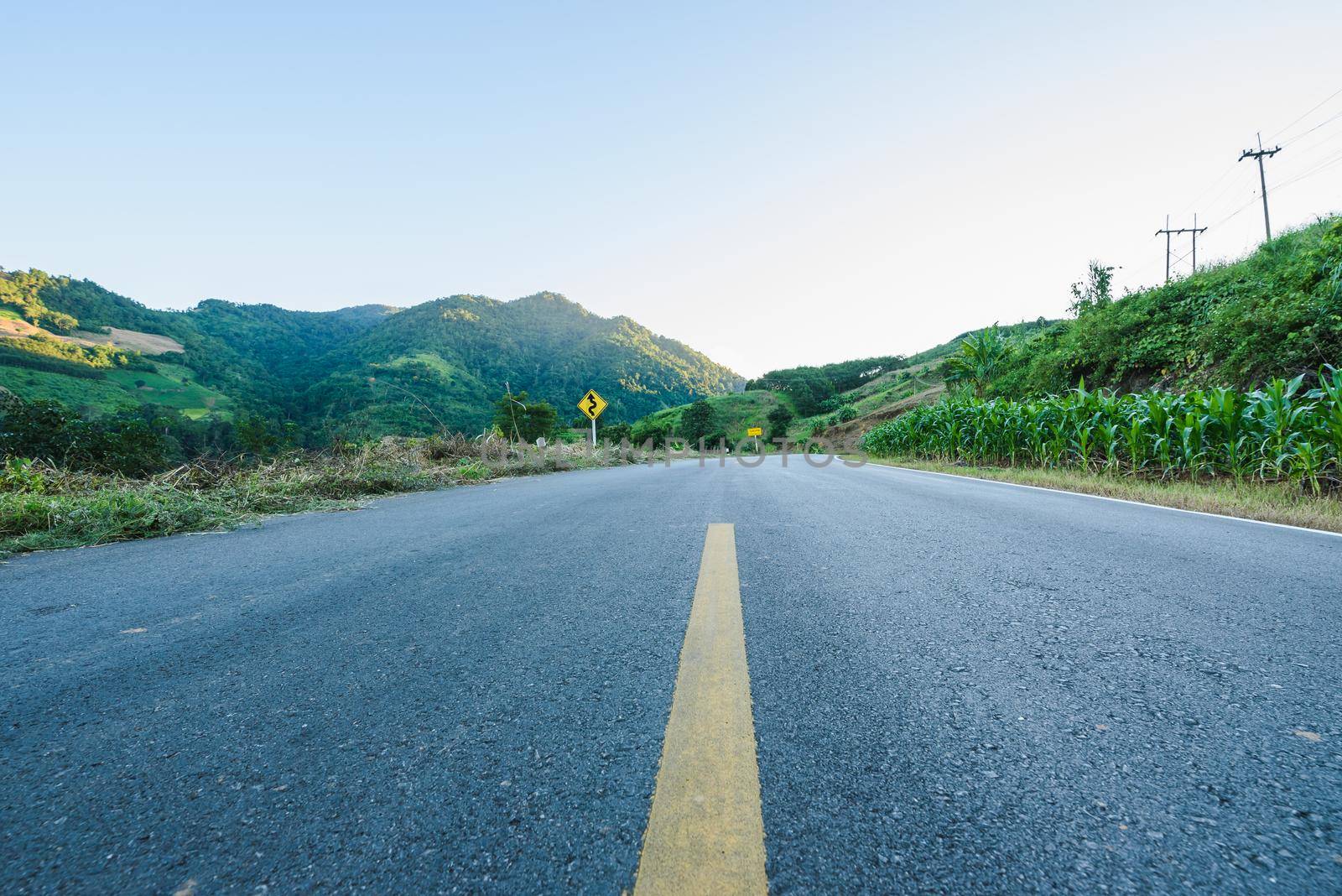 Winding road mountain blue sky by Wmpix