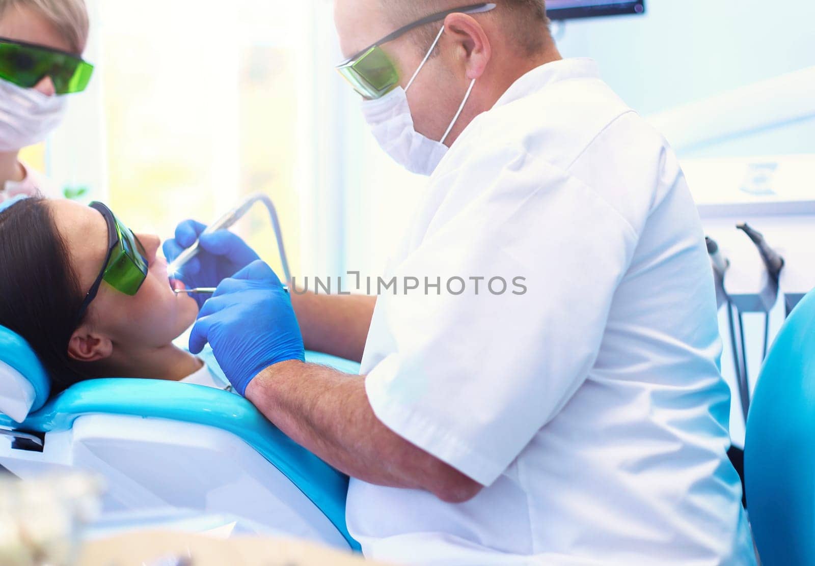 Man dentist working at his patients teeth.