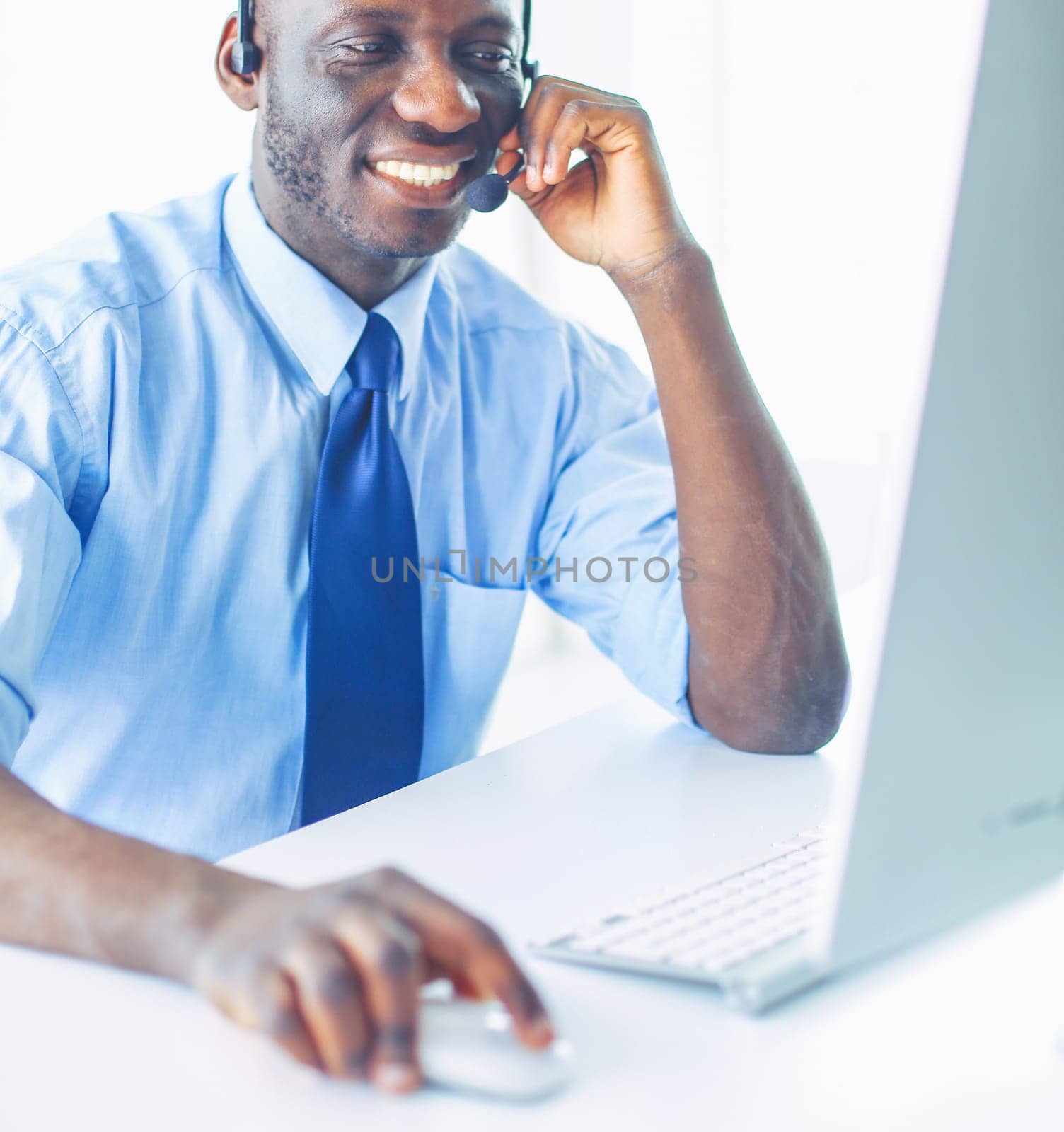 African american businessman on headset working on his laptop.