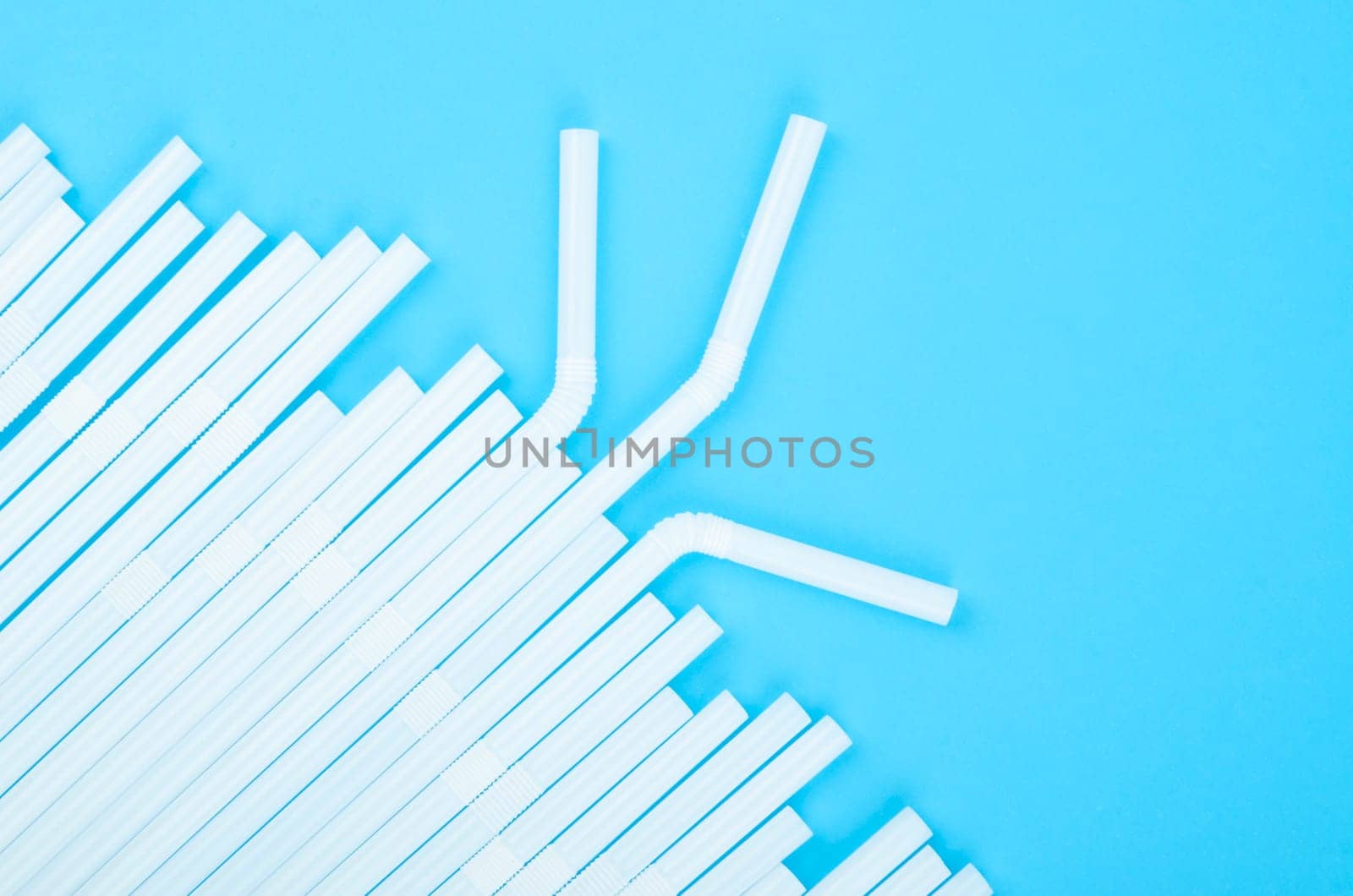 Group of plastic white drinking straw on blue background
