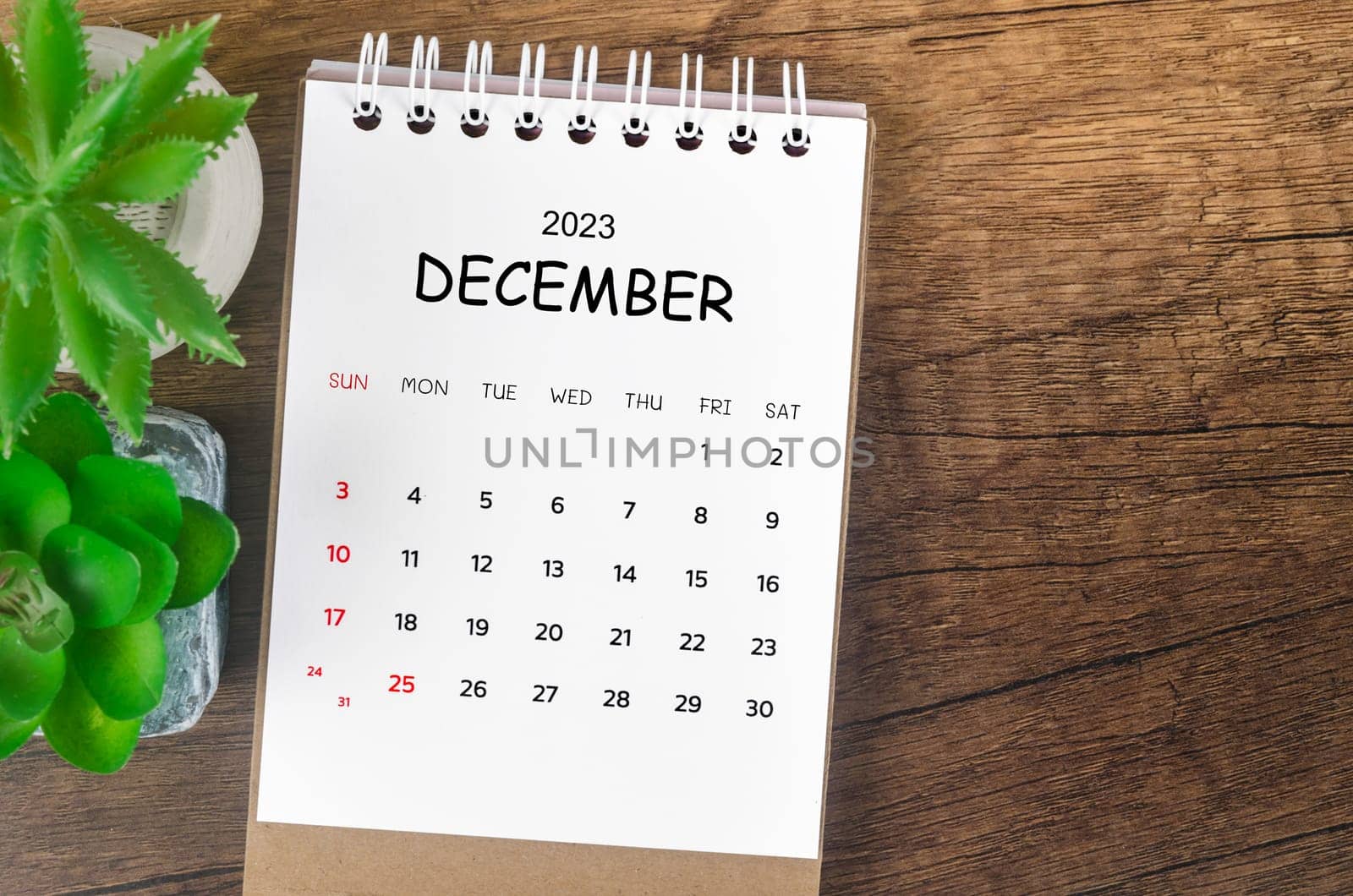 December 2023 desk calendar for 2023 on wooden background.