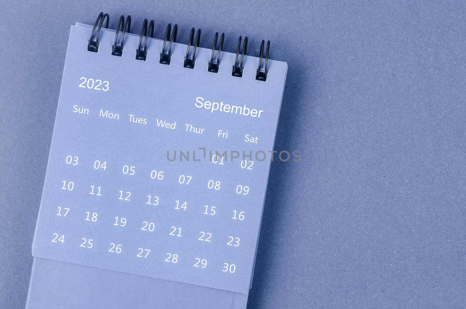 The September 2023 Monthly desk calendar for 2023 year on blue background. by Gamjai