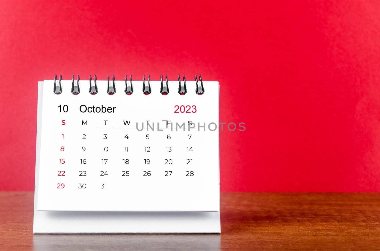 October 2023 desk calendar for 2023 year on Red color background.