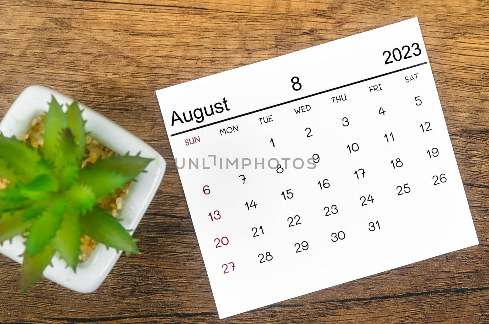 The August 2023 Monthly calendar for 2023 year on wooden background. by Gamjai