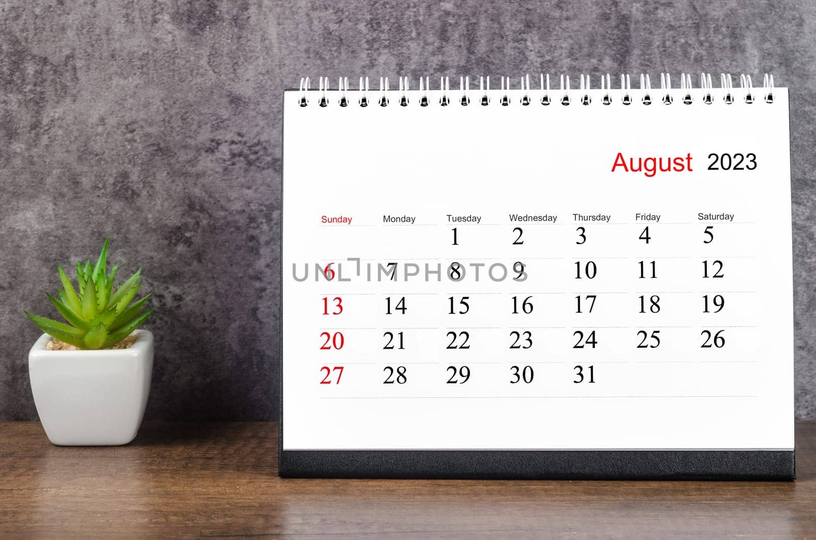 The August 2023 Monthly desk calendar for 2023 year on wooden table. by Gamjai