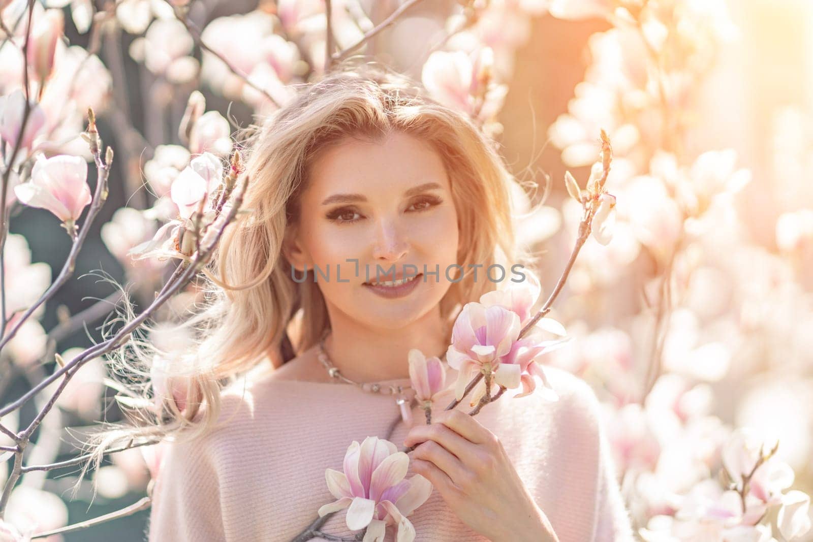 Magnolia woman portrait. Happy middle aged woman enjoying the smell in a blooming spring garden. Beautiful magnolia bushes, large flowers. by Matiunina