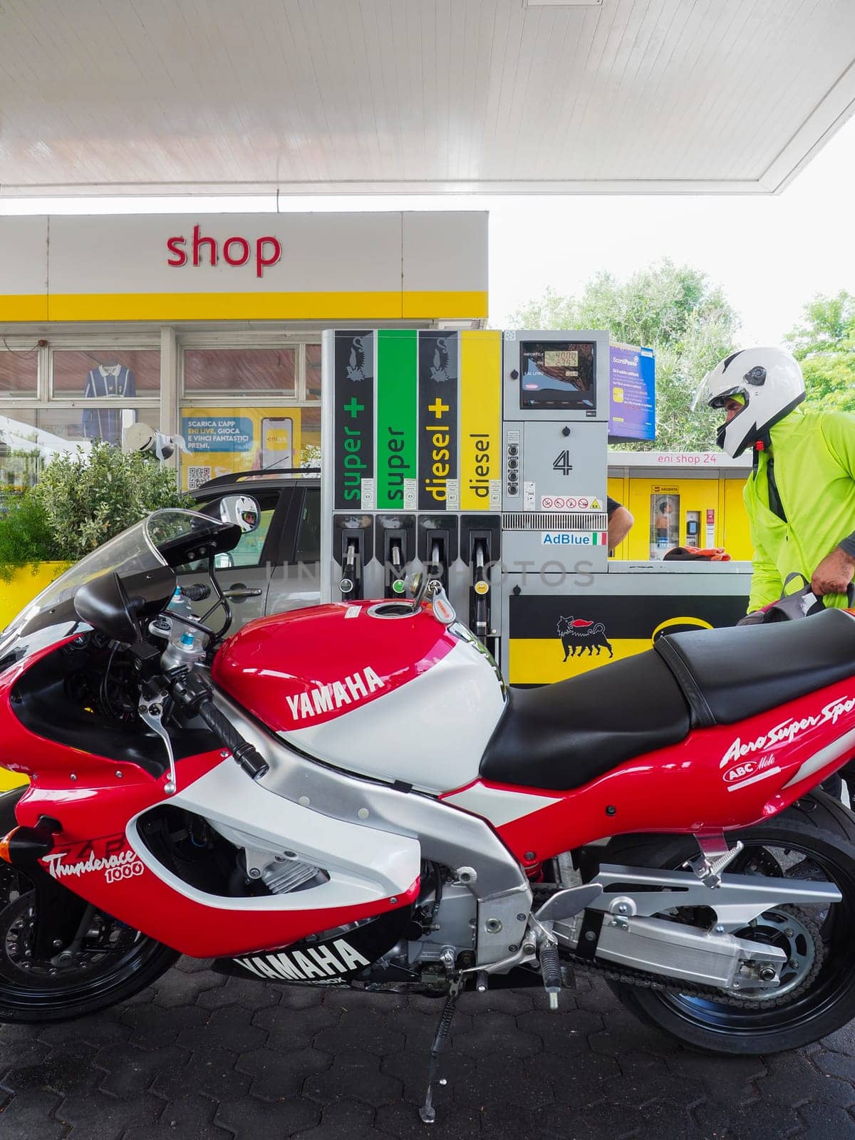 Cremona, Italy - July 3 2023 Customer self service refilling motorbikes at eni gas station