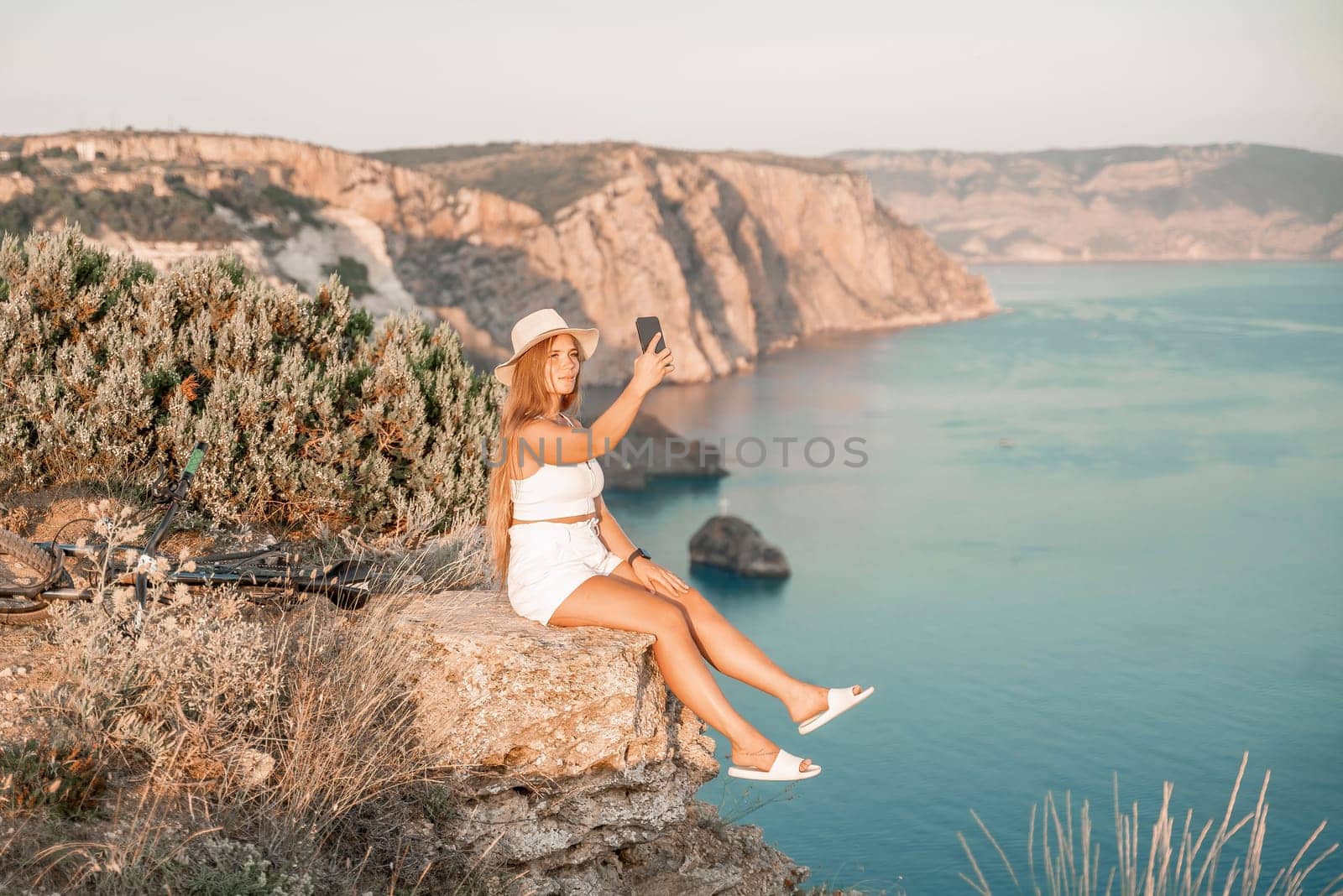 Selfie woman in cap and tank top making selfie shot mobile phone post photo social network outdoors on sea background beach people vacation lifestyle travel concept. by Matiunina