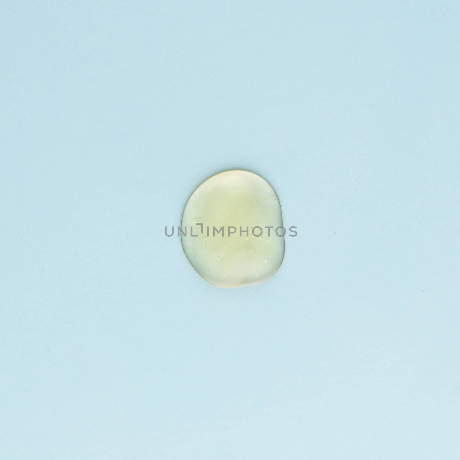 Drop of transparent face and body cream on a blue background