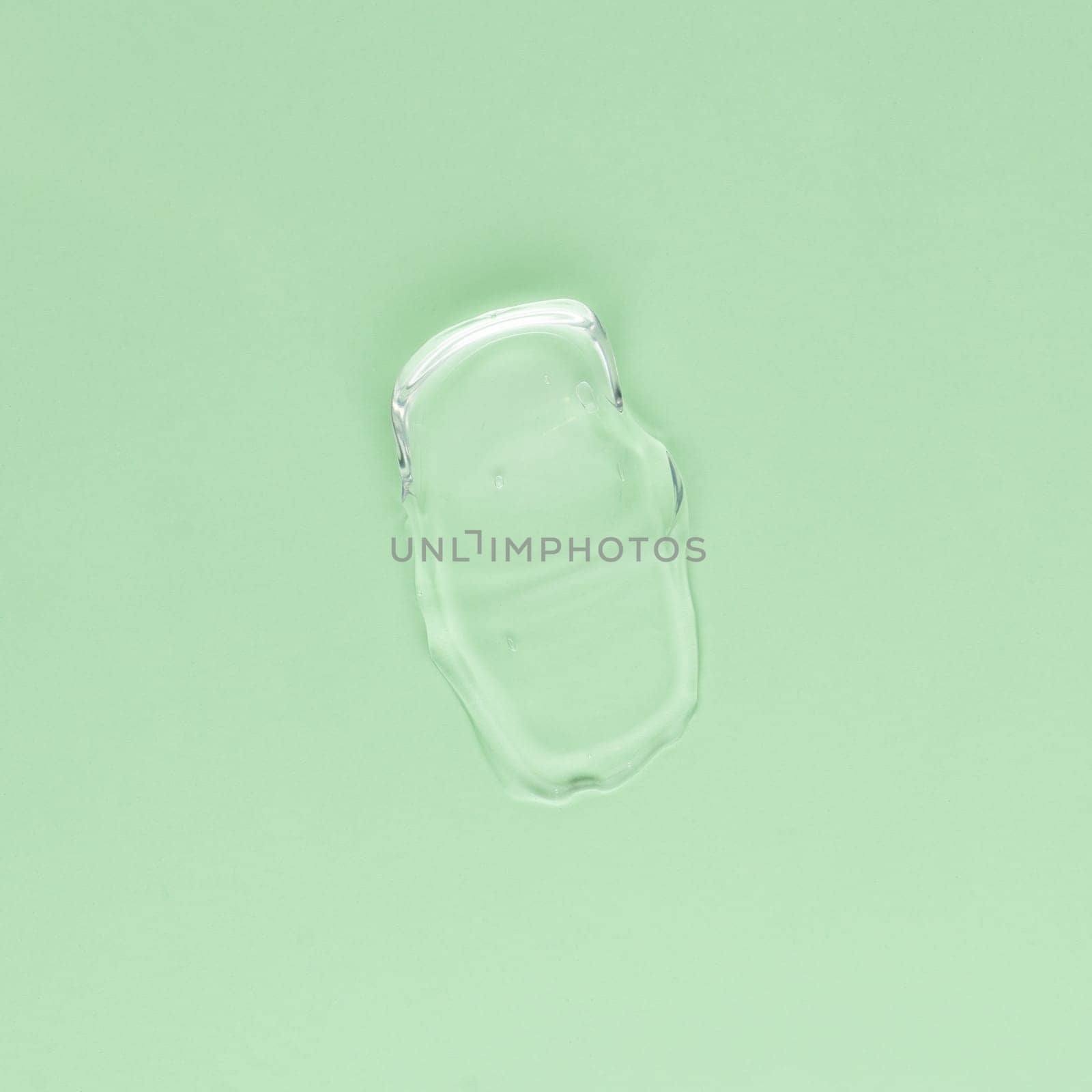 Smear of transparent cream for face and body on a green background