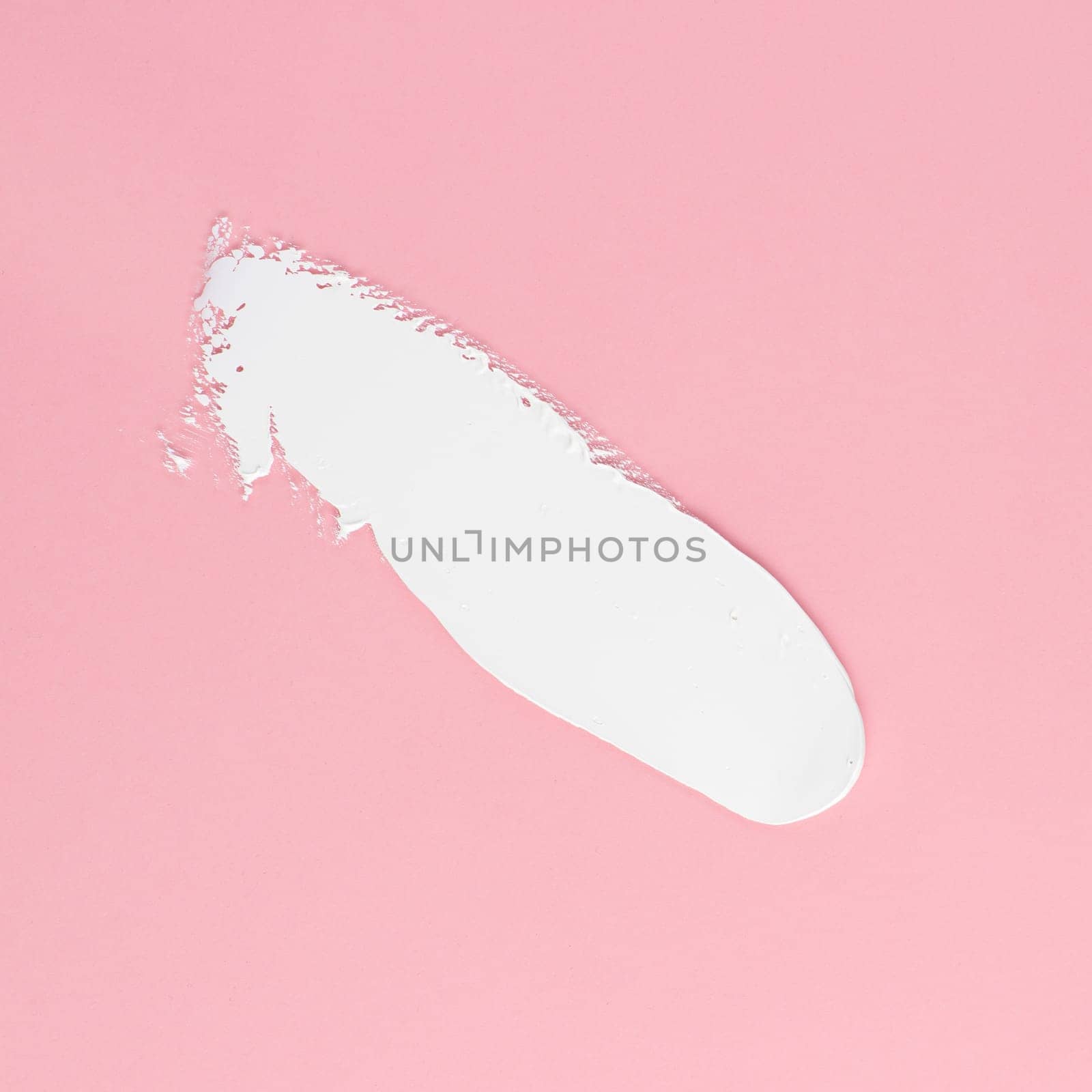 Smear of white cream for face and body on a pink background by A_Karim