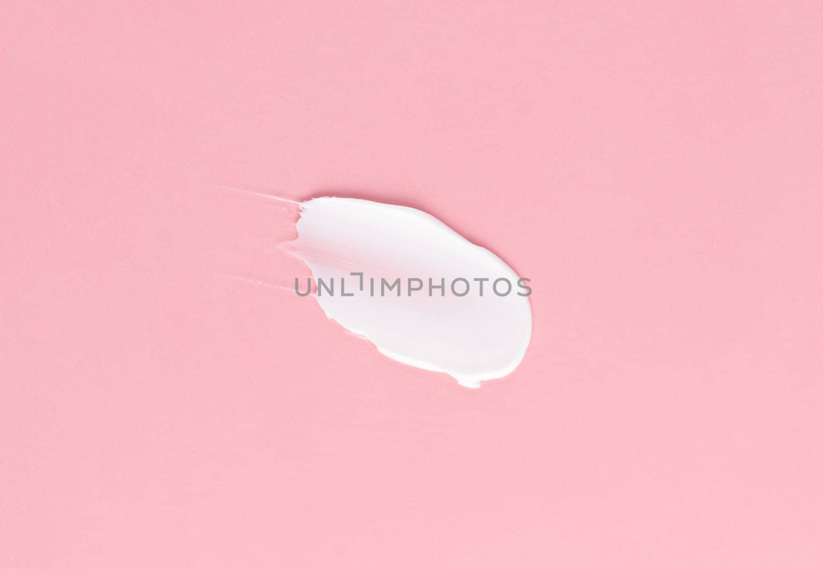 Smear of white cream for face and body on a pink background by A_Karim
