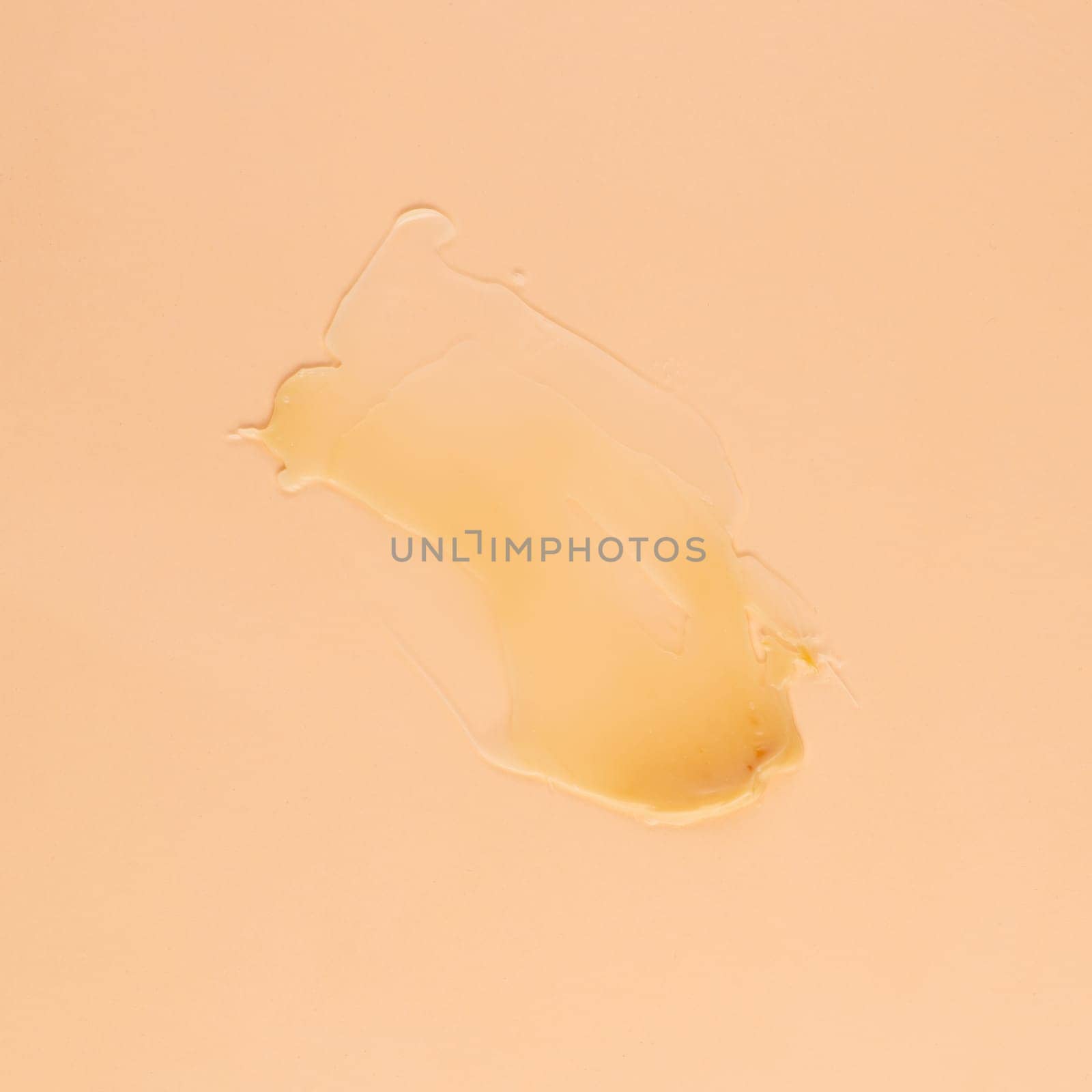 Smear of transparent cream for face and body on a brown background