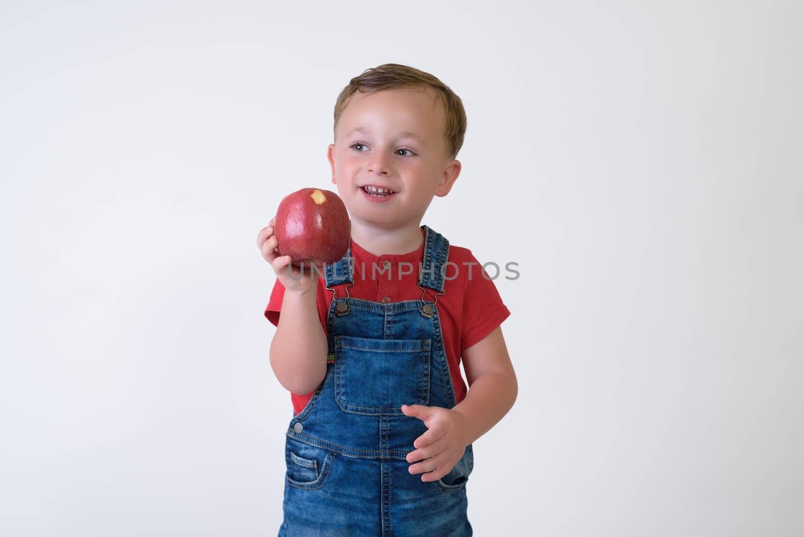 portrait of a girl eating red apple isolated on white. Healthy nutrition. free space.