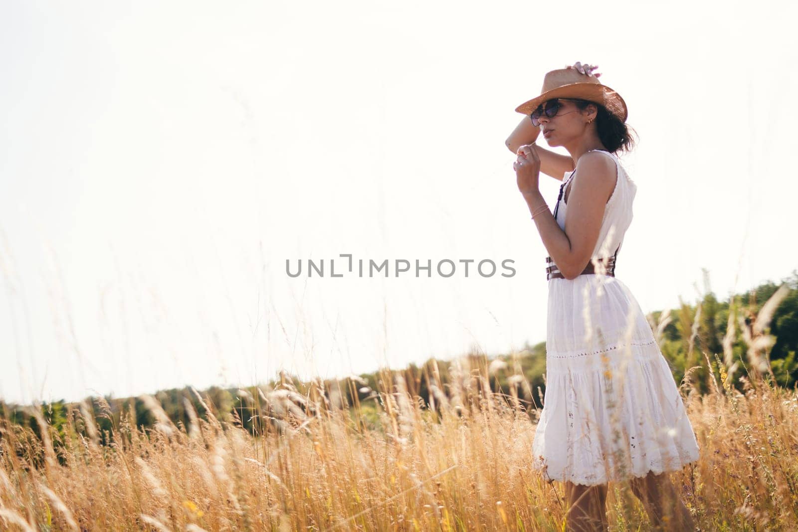Portrait of woman in golden sunset light in outdoor meadow. Springtime and summer lifestyle. Wellbeing and zen like meditation activity in outdoor. Loving life. by sarymsakov