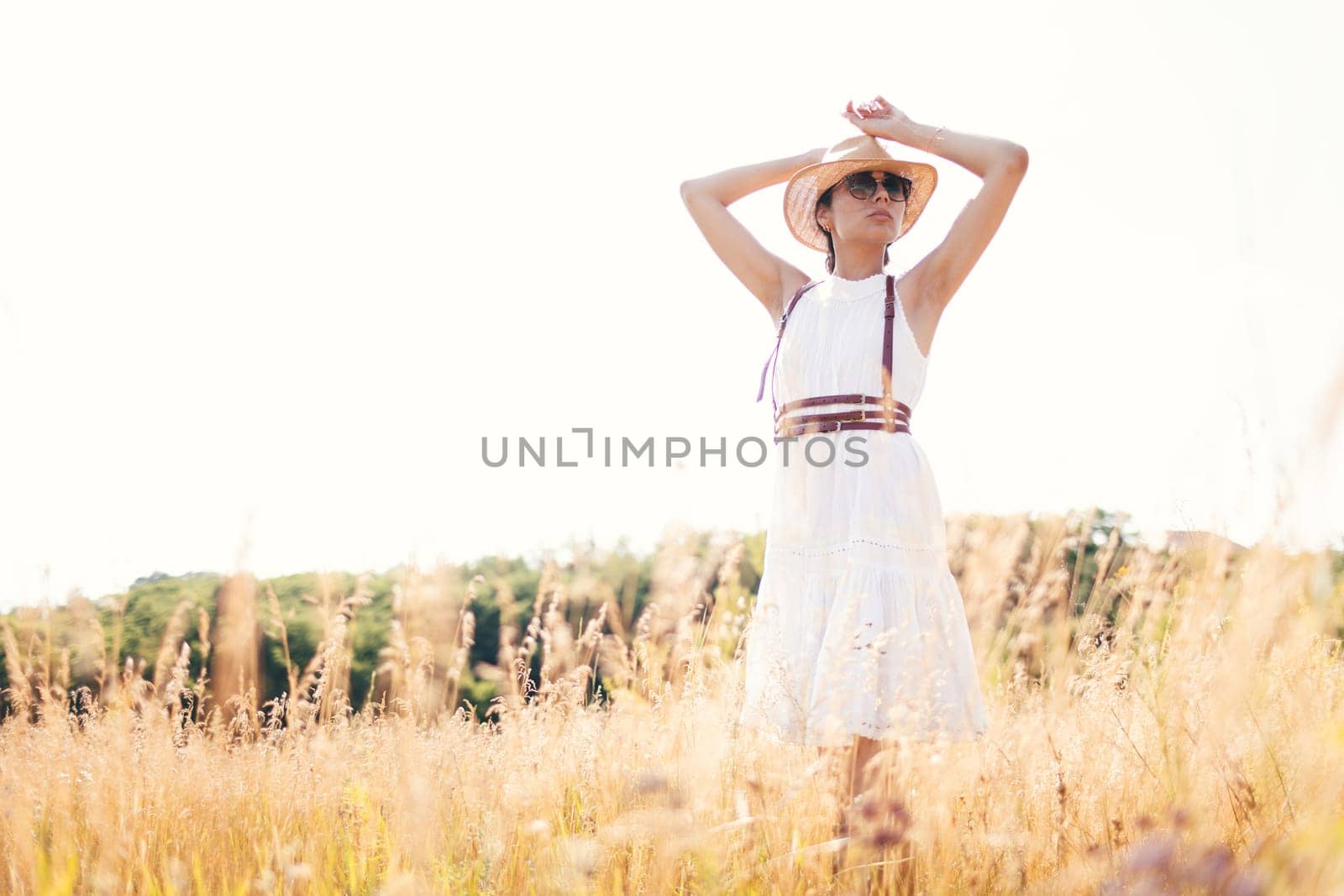 Beautiful girl in a linen dress in a wheat field. Summer vacation, traveling. Bohemian, modern hippie style.