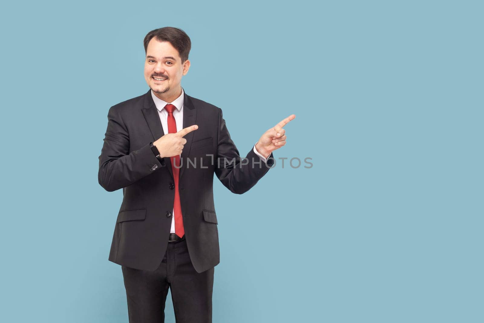 Smiling man with mustache pointing aside at empty space for advertisement or promotional text. by Khosro1